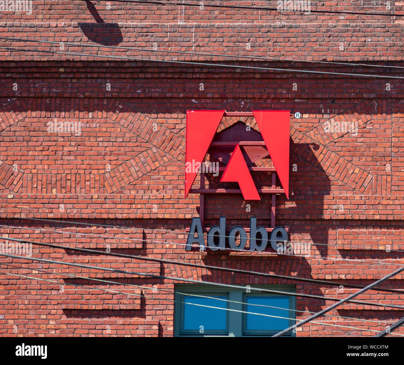 Adobe Logo auf dem Backstein Büro Fassade der computer software unternehmen, das sich auf die Erstellung von Multimedia- und Kreativität Software Produkte Stockfoto