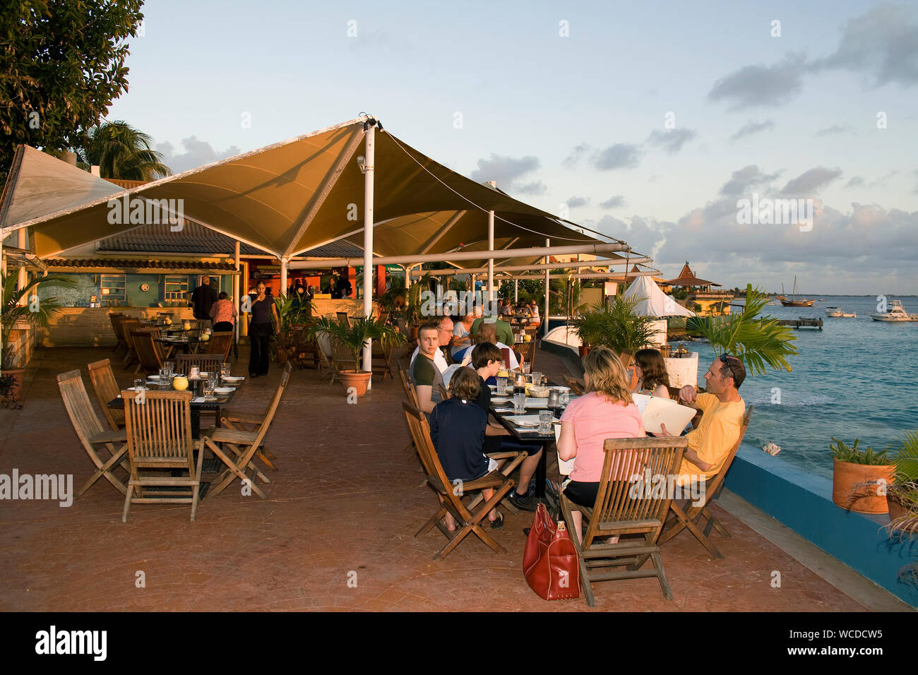 Touristen in einem Restaurant mit Meerblick, Sonnenuntergang am Captain Don's Habitat, berühmten Resort Tauchen hotel, Kralendijk, Bonaire, Niederländische Antillen Stockfoto