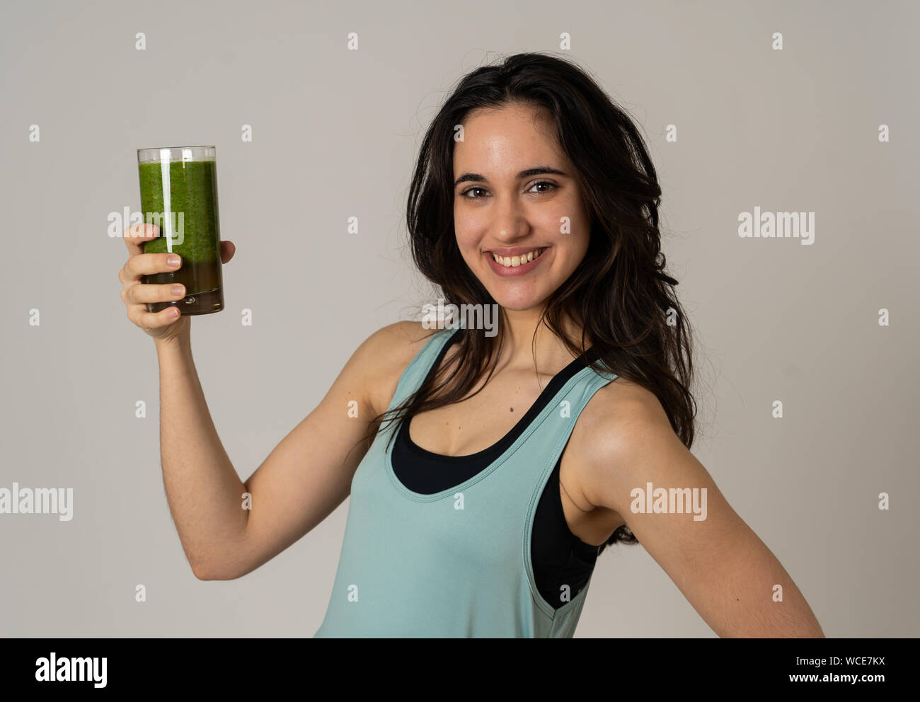 Fitness Frau glücklich lächelnde Holding Glas grünes Gemüse Smoothie nach dem Ausführen oder Training. Portrait isoliert mit kopieren. Schönheit Gesundheit Fitne Stockfoto