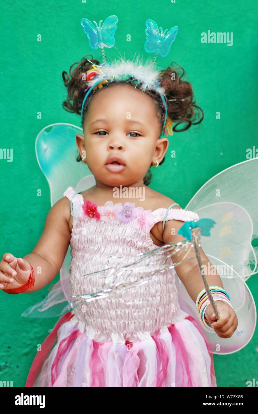 Portrait von niedlichen Baby Mädchen mit Fee Kostüm gegen die Wand  Stockfotografie - Alamy