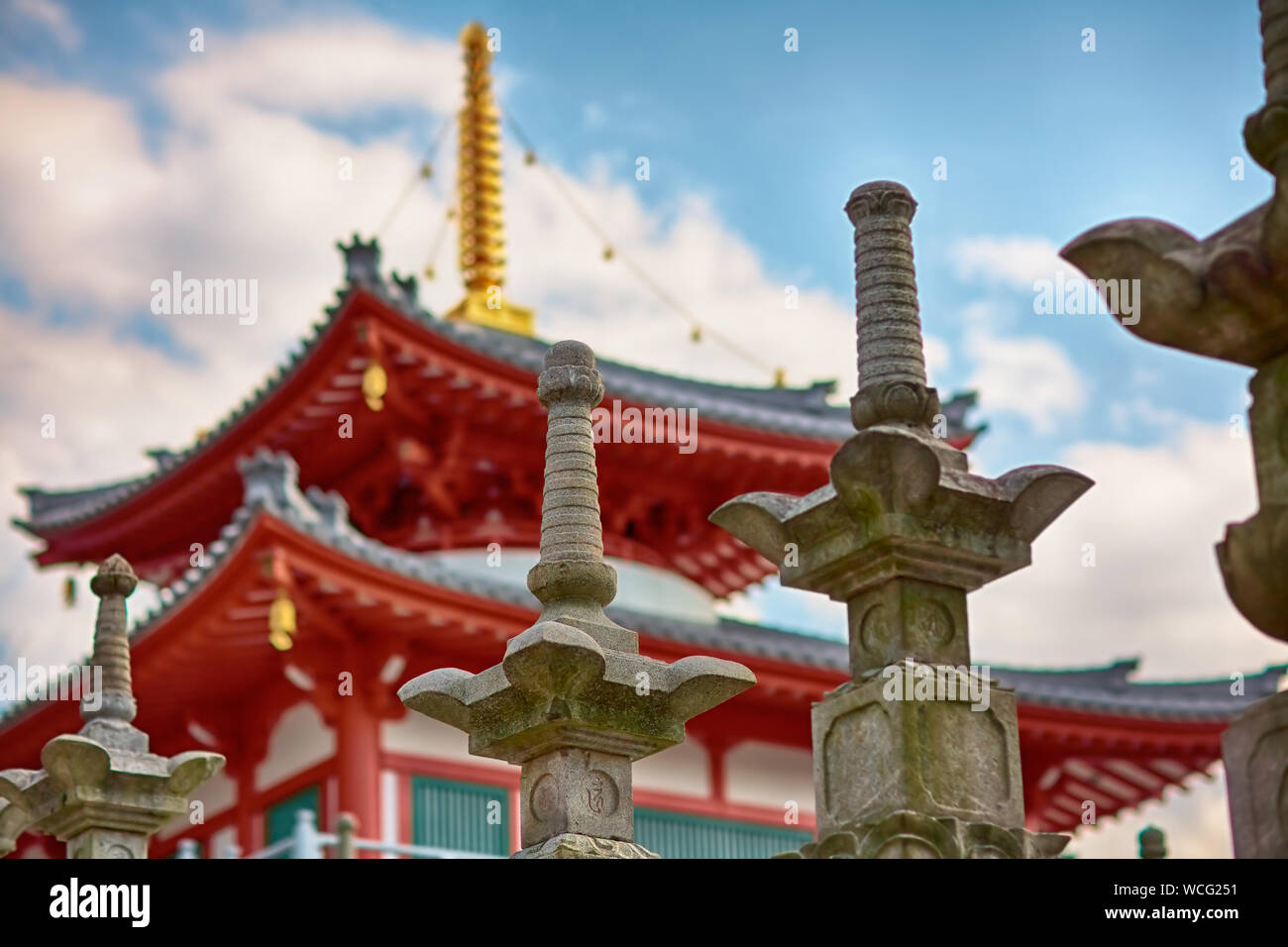 Steinlaternen und buddhistische Tempel unter blauem Himmel mit Wolken in Nagoya, Japan Stockfoto