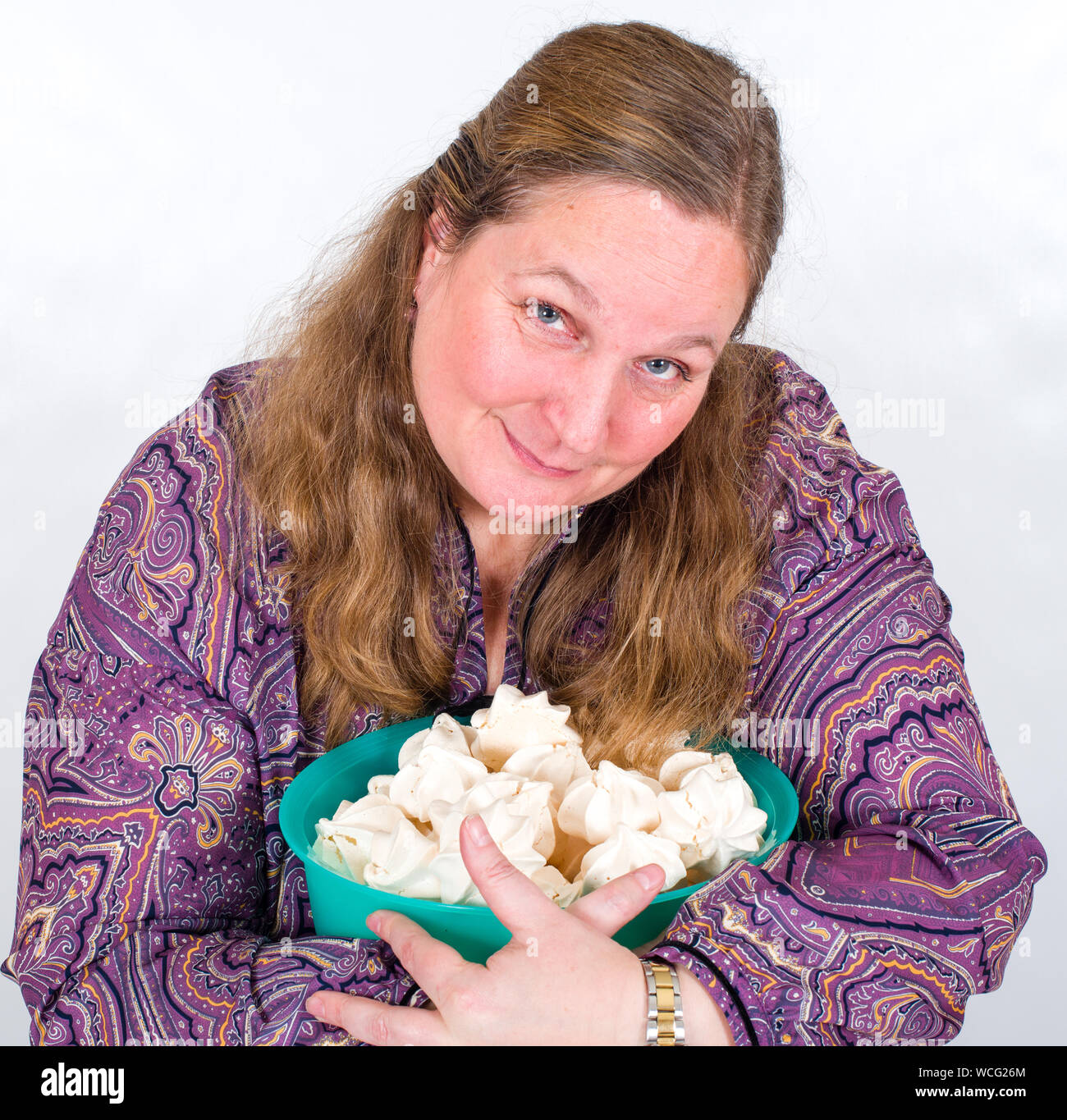 Close-up Portrait von Reife Frauen Holding süße Speisen in Schüssel gegen weißen Hintergrund Stockfoto