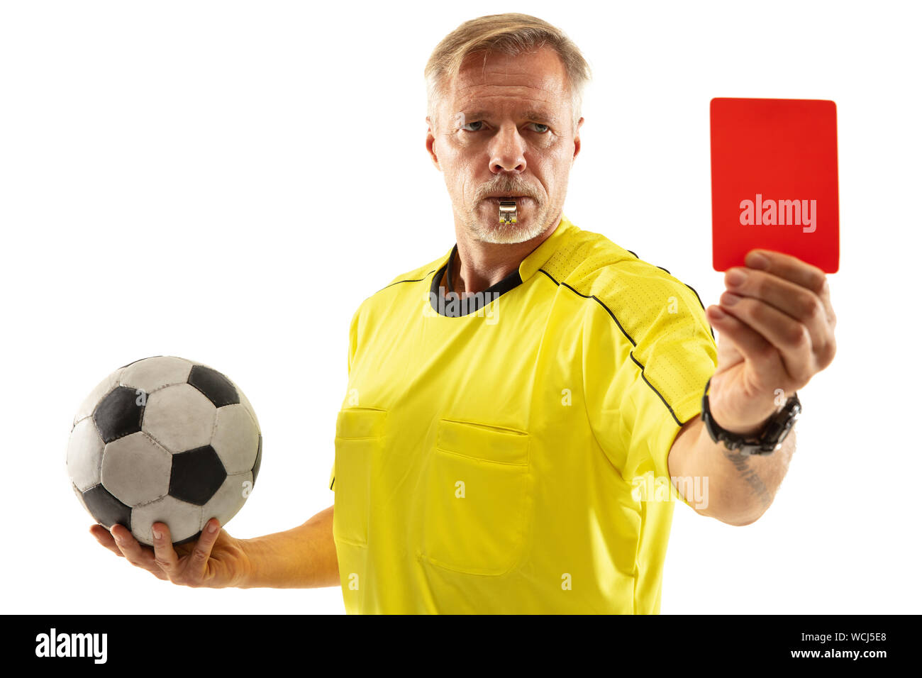 Schiedsrichter holding Ball und zeigt eine rote Karte gegen einen Fußball oder Soccer player Gaming auf weißem Studiohintergrund. Konzept für Sport, Richtlinien Verletzung, strittige Fragen, Hindernisse zu überwinden. Stockfoto