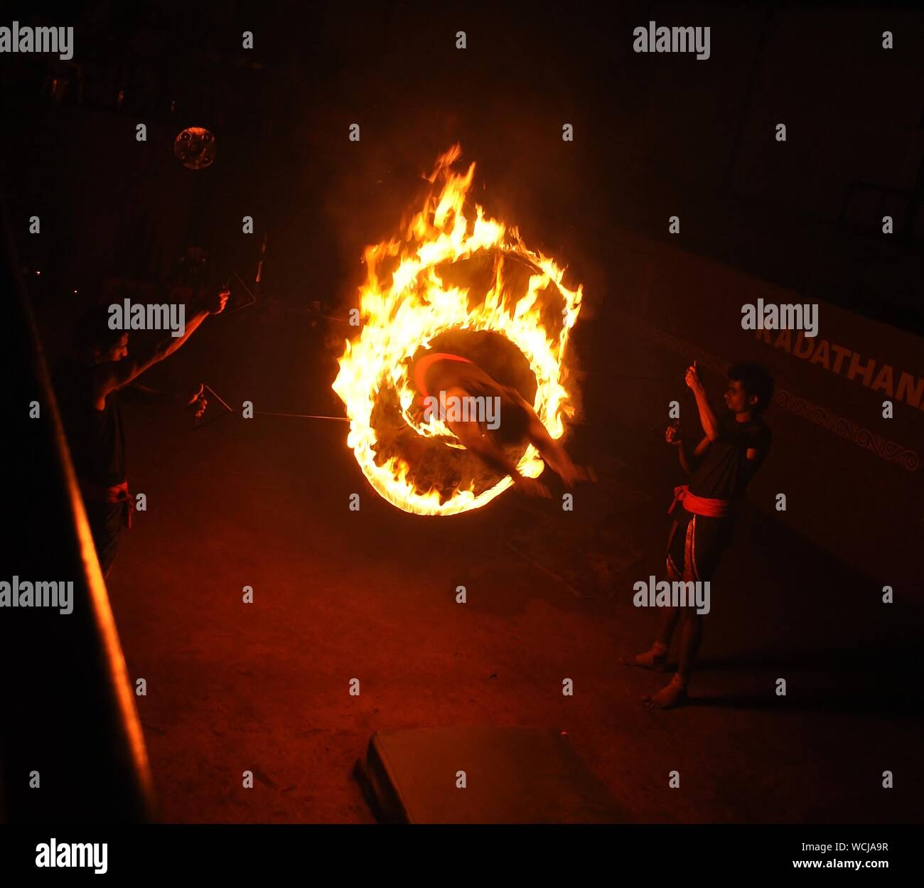 Man hüpft durch brennende Ringe von Feuer in der Nacht Stockfotografie -  Alamy