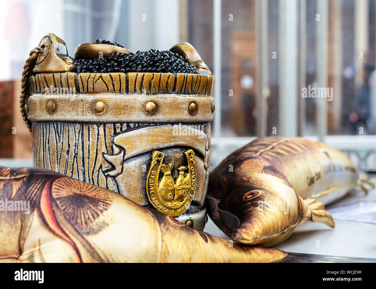 Schwarzer Kaviar in ein Fass mit einem Löffel. Die Inschrift auf dem Hufeisen - Bleiben Sie gesund und Reich leben. Stockfoto