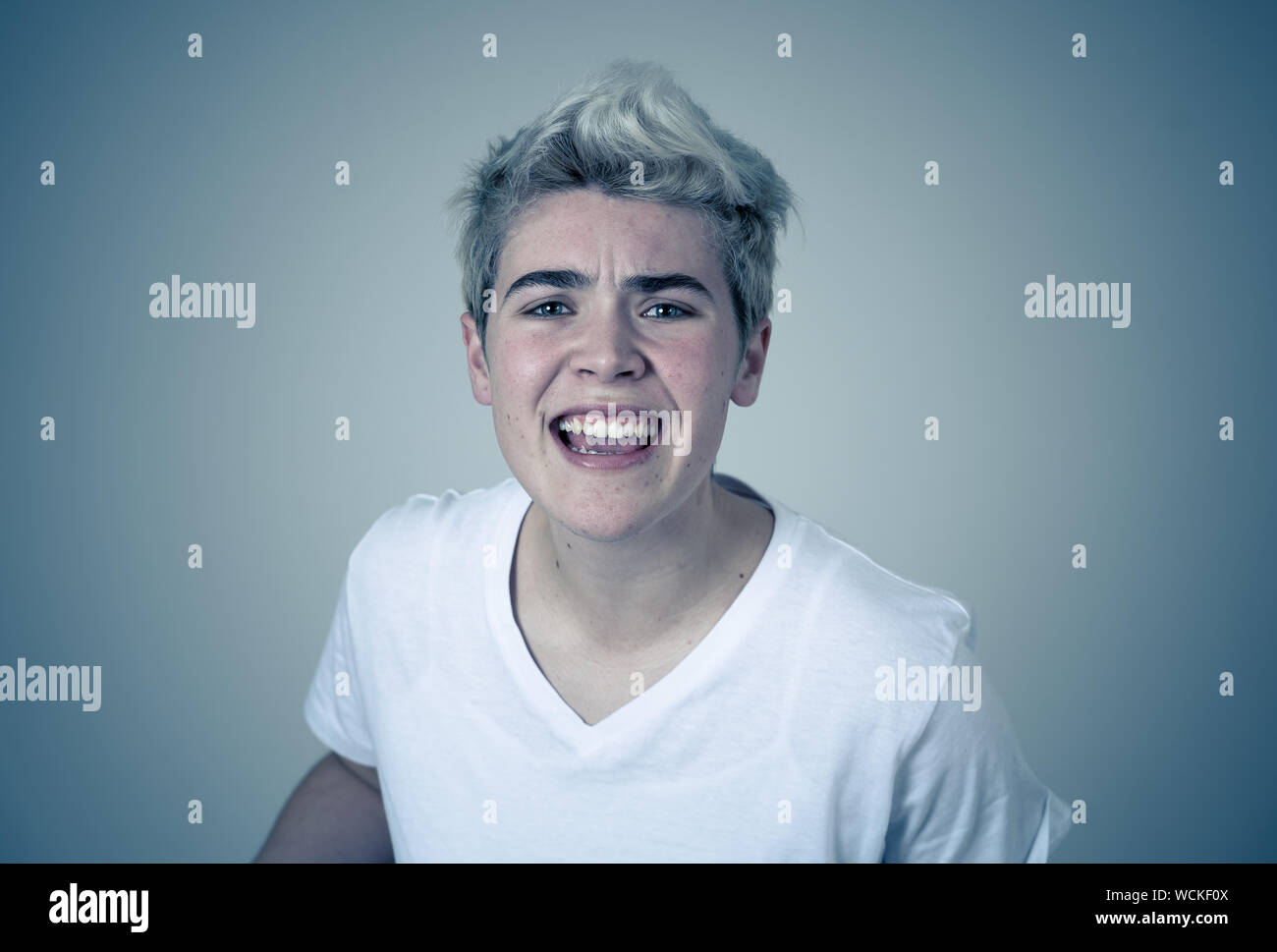 Porträt der jungen attraktiven transgender Teenager Mann mit wütend das Gesicht. Suche sauer und wütend. Mimik und Emotionen. Auf isoliertem Sternpunkt b Stockfoto