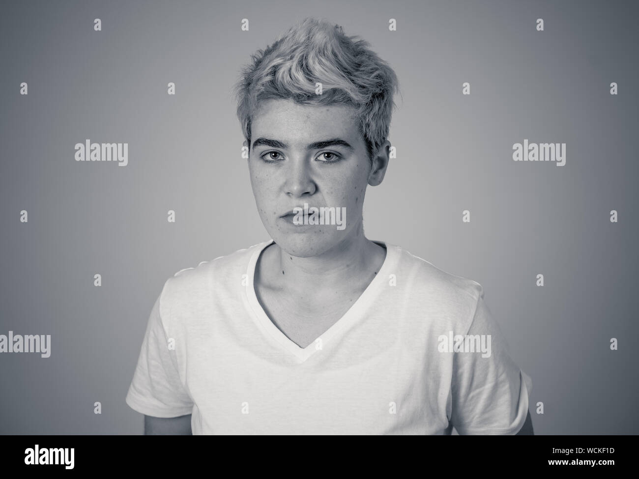 Porträt der jungen attraktiven transgender Teenager Mann mit wütend das Gesicht. Suche sauer und wütend. Mimik und Emotionen. Auf isoliertem Sternpunkt b Stockfoto