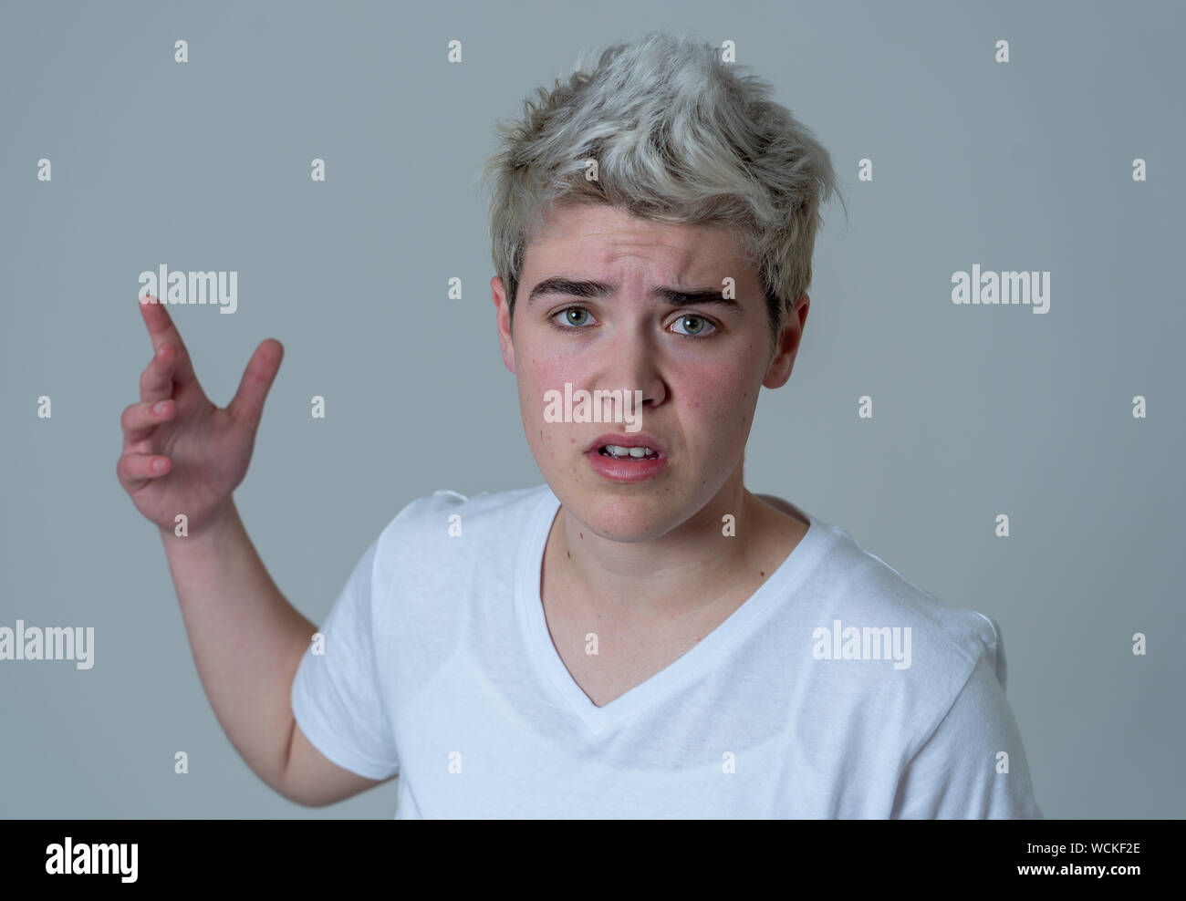 Porträt der jungen attraktiven transgender Teenager Mann mit wütend das Gesicht. Suche sauer und wütend. Mimik und Emotionen. Auf isoliertem Sternpunkt b Stockfoto