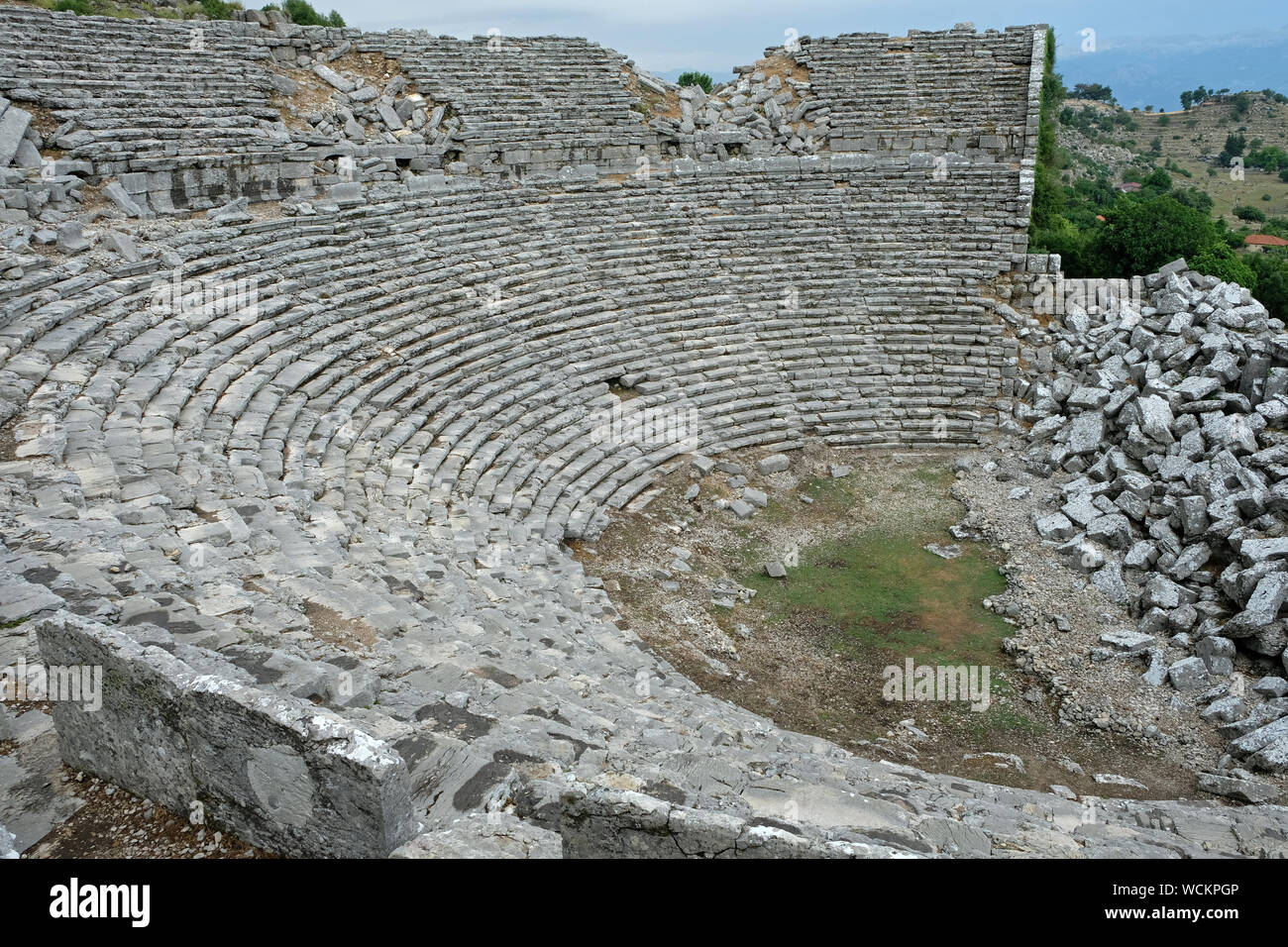 Die Ruinen des antiken Theaters von Selge stand unter den modernen Gebäuden eines kleinen Dorfes. Stockfoto