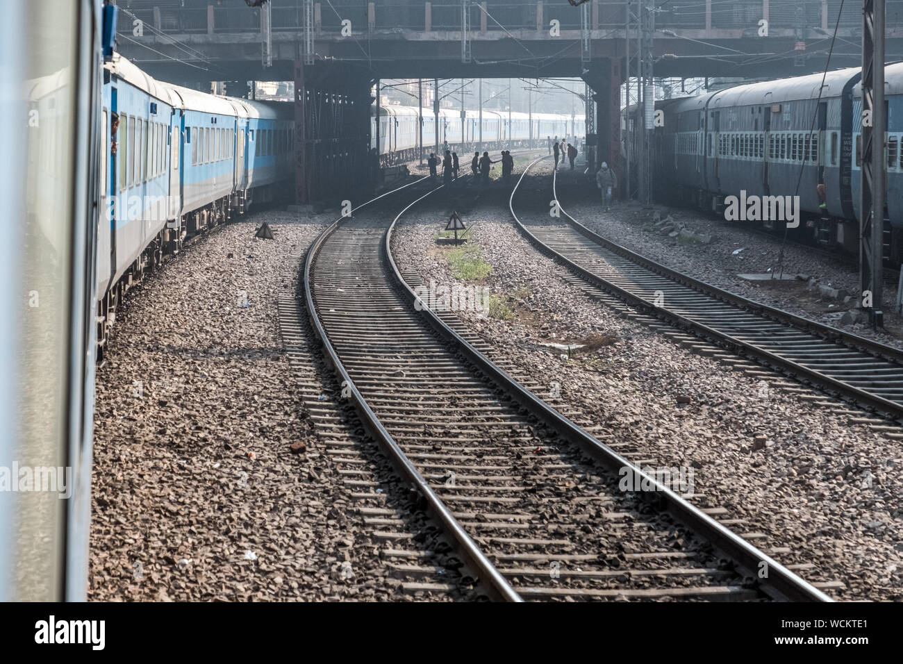 Eine lange indische Eisenbahn Zug in die Ferne geschwungene wie Delhi, Indien tritt Stockfoto