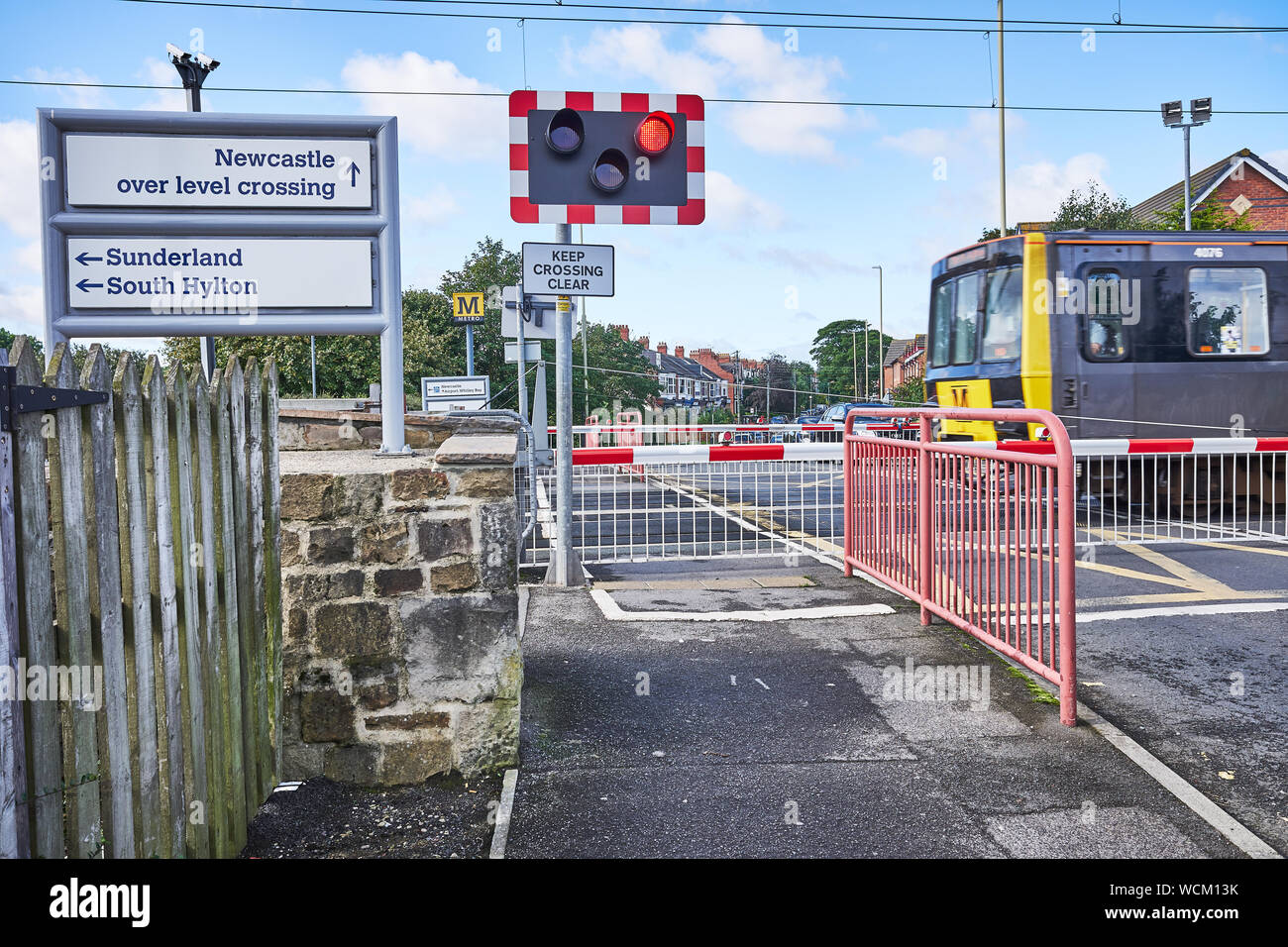 Zug der Tyne und Metro Verschleiß überquert die Straße am East Boldon, South Tyneside, England. Stockfoto