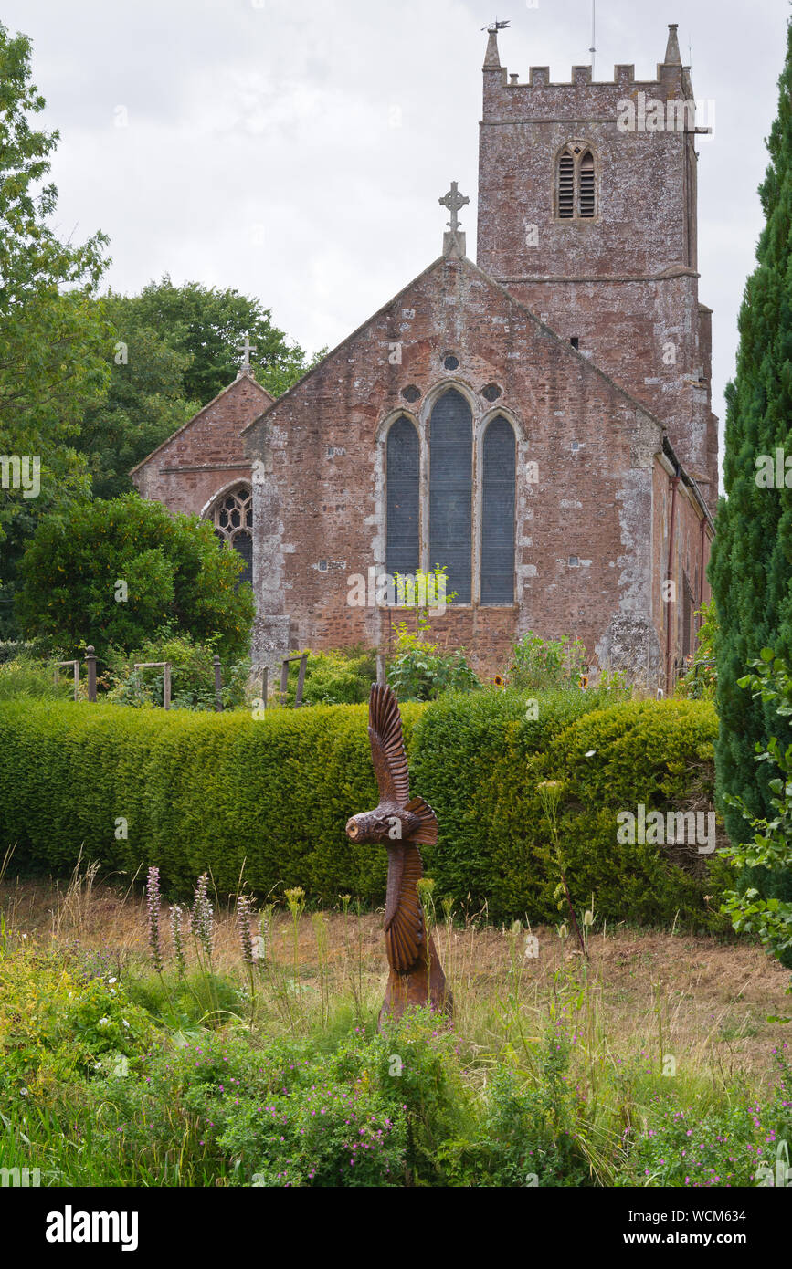 Eine Eule Skulpturen aus einem Baumstamm am Ufer des Tiverton Kanal vor der Hl. Johannes der Täufer Kirche in Sampford Peverell in Devon, England Stockfoto