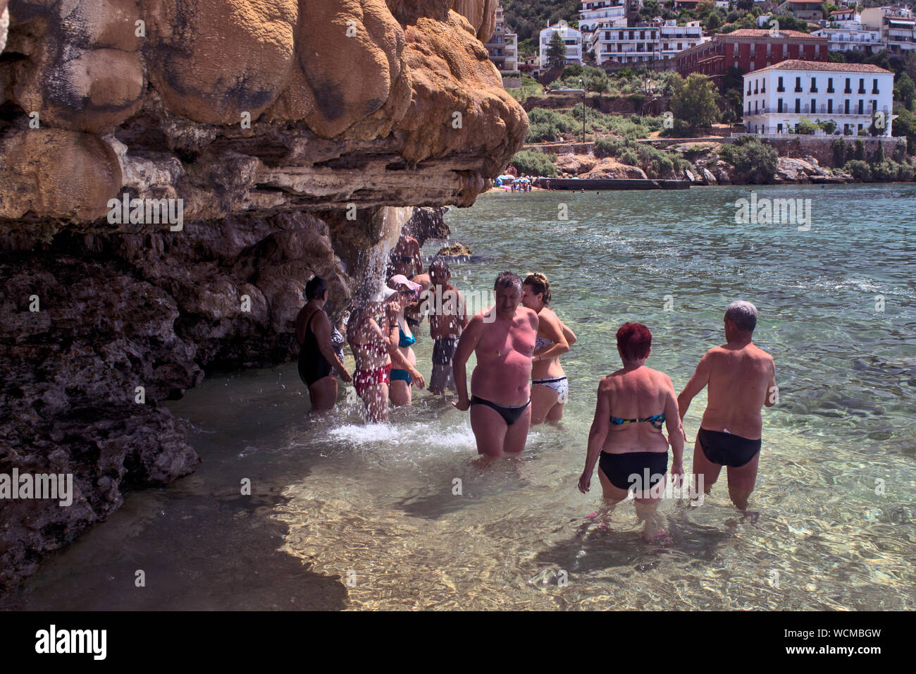 Evia Insel, Loutra Edipsou, Griechenland, Juni 05, 2016. Genießen Touristen, die sich in der warmen Arzneimittel spa Wasser aus dem Felsen an der Küste der Ägäis. Stockfoto