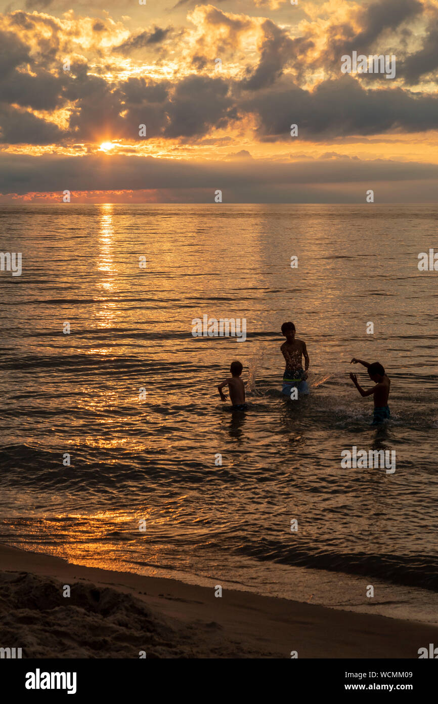 Union Pier, Michigan - Kinder spielen wie die Sonne über den Lake Michigan setzt. Stockfoto