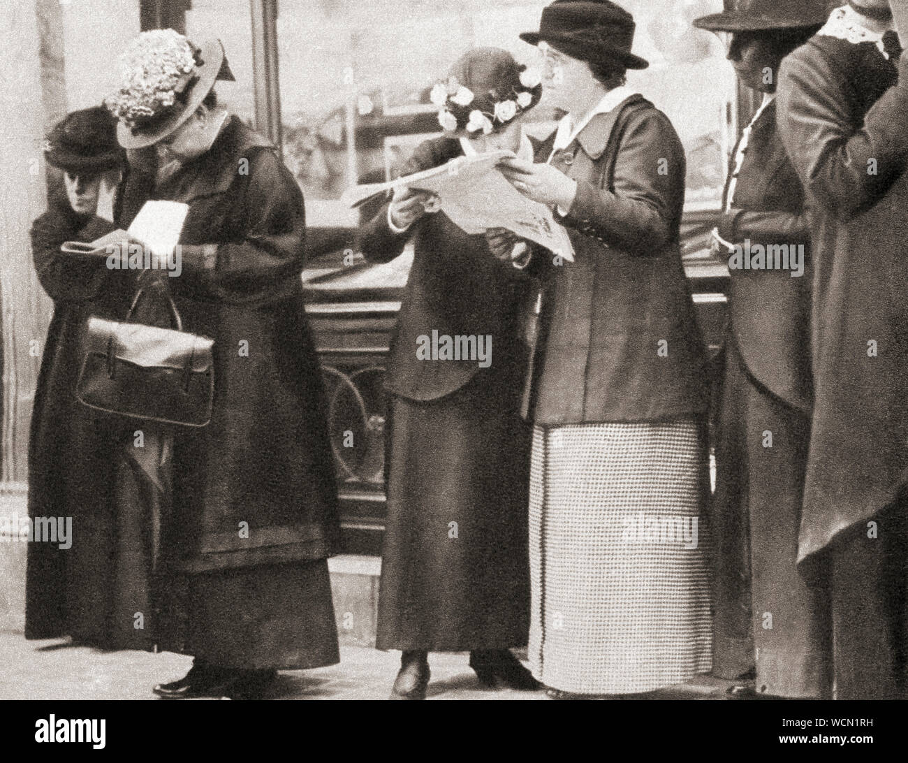 Menschenmassen versammeln sich außerhalb der Cunard Büros in London, um die Nachricht von der Versenkung der Lusitania durch ein deutsches U-Boot 1915 zu lesen. Aus dem Festzug des Jahrhunderts, veröffentlicht 1934. Stockfoto