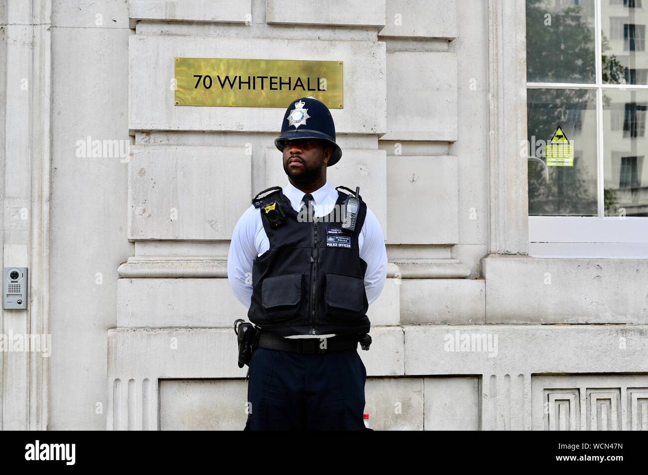 Die Metropolitan Police Officer bewacht den Eingang des Cabinet Office, Whitehall, London. Großbritannien Stockfoto