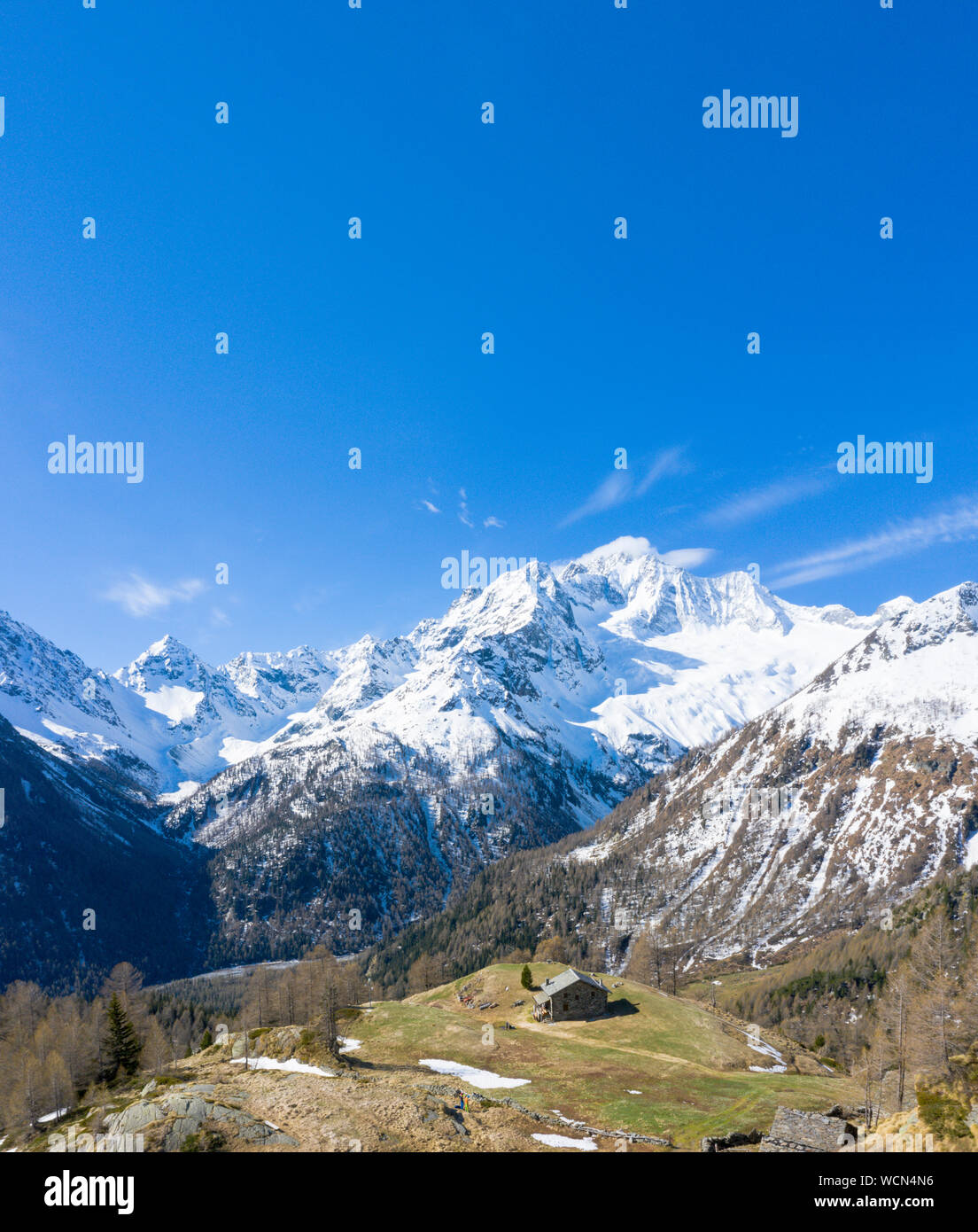 Antenne Panoramablick auf die schneebedeckten Monte Disgrazia und Hütten in Alpe Oro, Valmalenco, Veltlin Sondrio Provinz, Lombardei, Italien Stockfoto