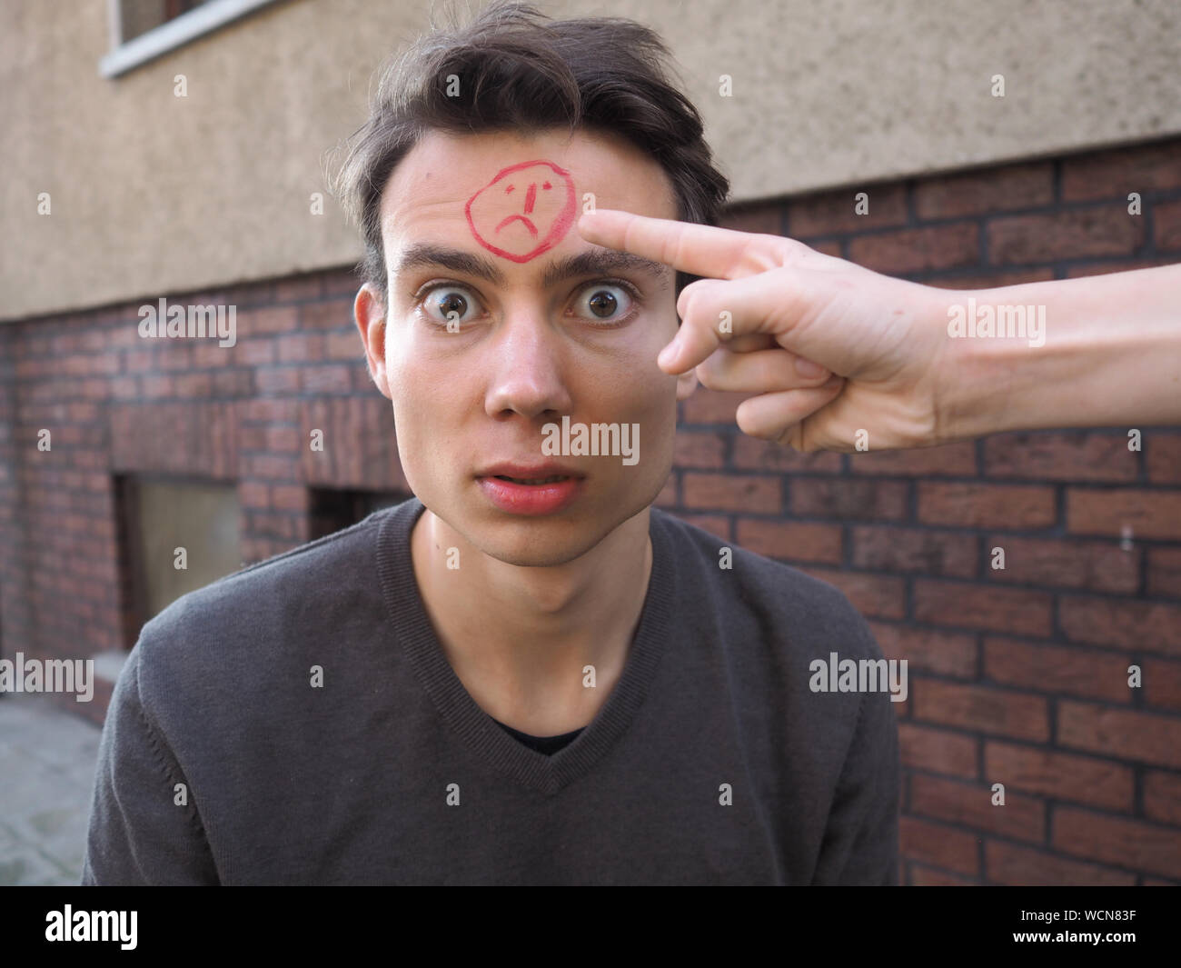 Zugeschnittenes Bild von Hand zeigen auf Mann Gesicht mit Traurige