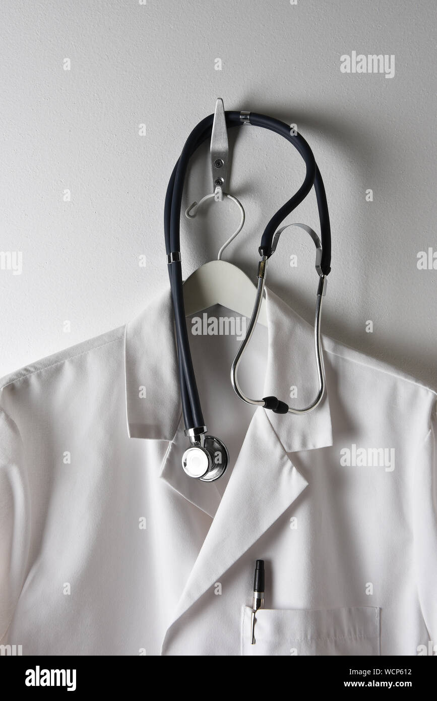 Ein Ärzte weißen Kittel auf einem Kleiderbügel an einem Haken mit Stethoskop, Stift in der Tasche. Stockfoto