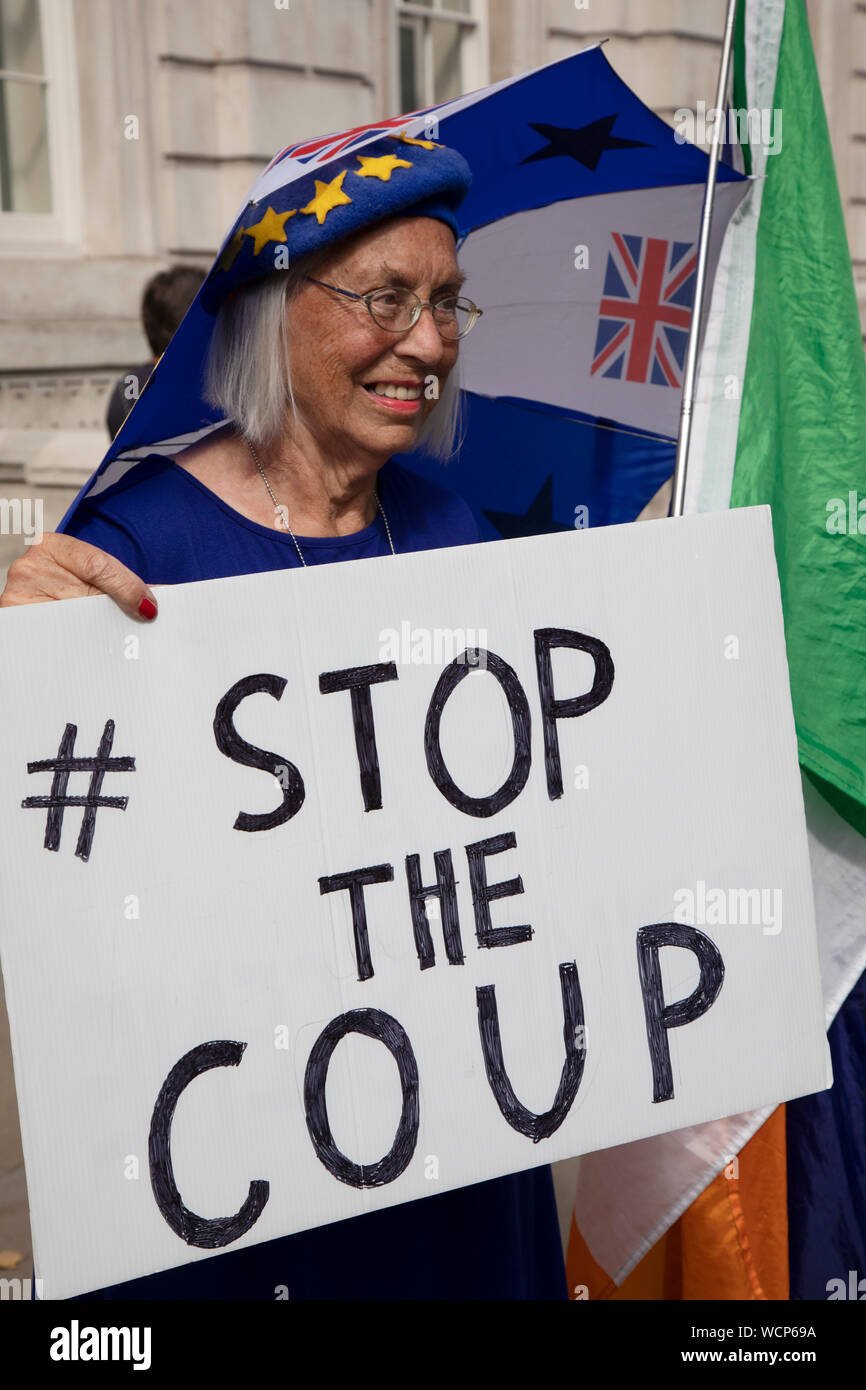 Anti Brexit Demonstranten schwenkten Fahnen der Europäischen Union und eine mit einem Stop der Putsch Plakat außerhalb des Cabinet Office in Westminster, wie es ist bekannt, dass Boris Johnson seine Anfrage an das Parlament von der Königin am 28. August 2019 in London, England, Vereinigten Königreich genehmigt auszusetzen gehabt hat. Die Ankündigung einer Aussetzung des Parlaments für etwa fünf Wochen vor der Brexit hat wütend bleiben Unterstützer, die vorschlagen, dies ist ein Finsterer Plan die Debatte über eine mögliche Kein Abkommen zu stoppen. Stockfoto