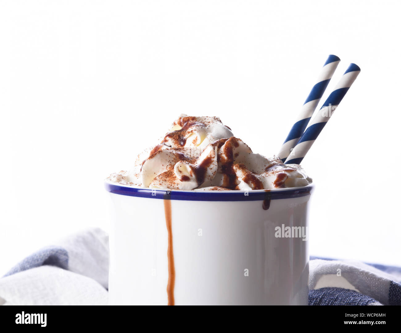 Nahaufnahme von einem weißen Tasse heiße Schokolade mit Sahne und zwei Papier Trinkhalme. Stockfoto