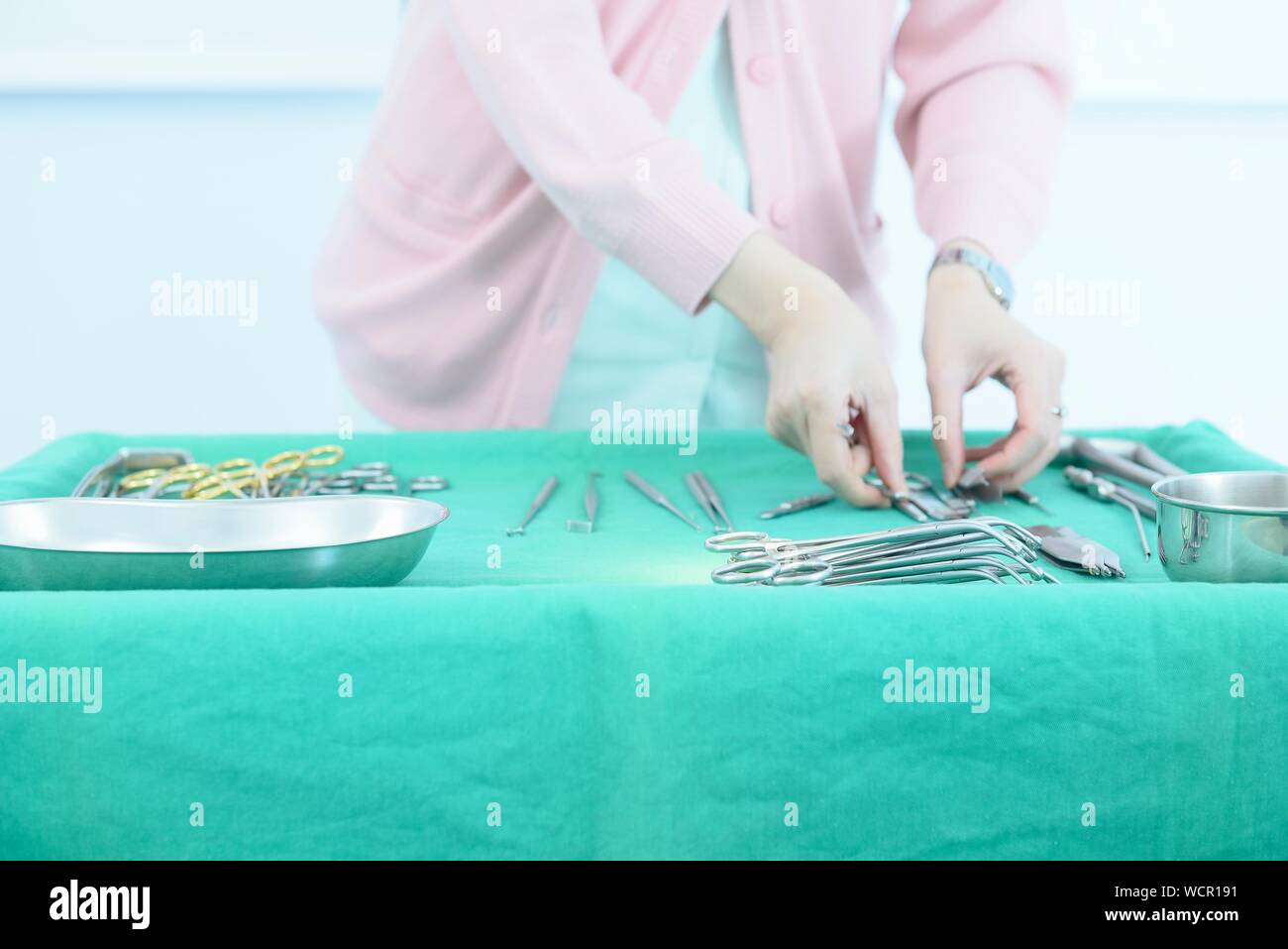Mittelteil der weiblichen Arzt Anordnen medizinisches Instrument auf Tisch Stockfoto