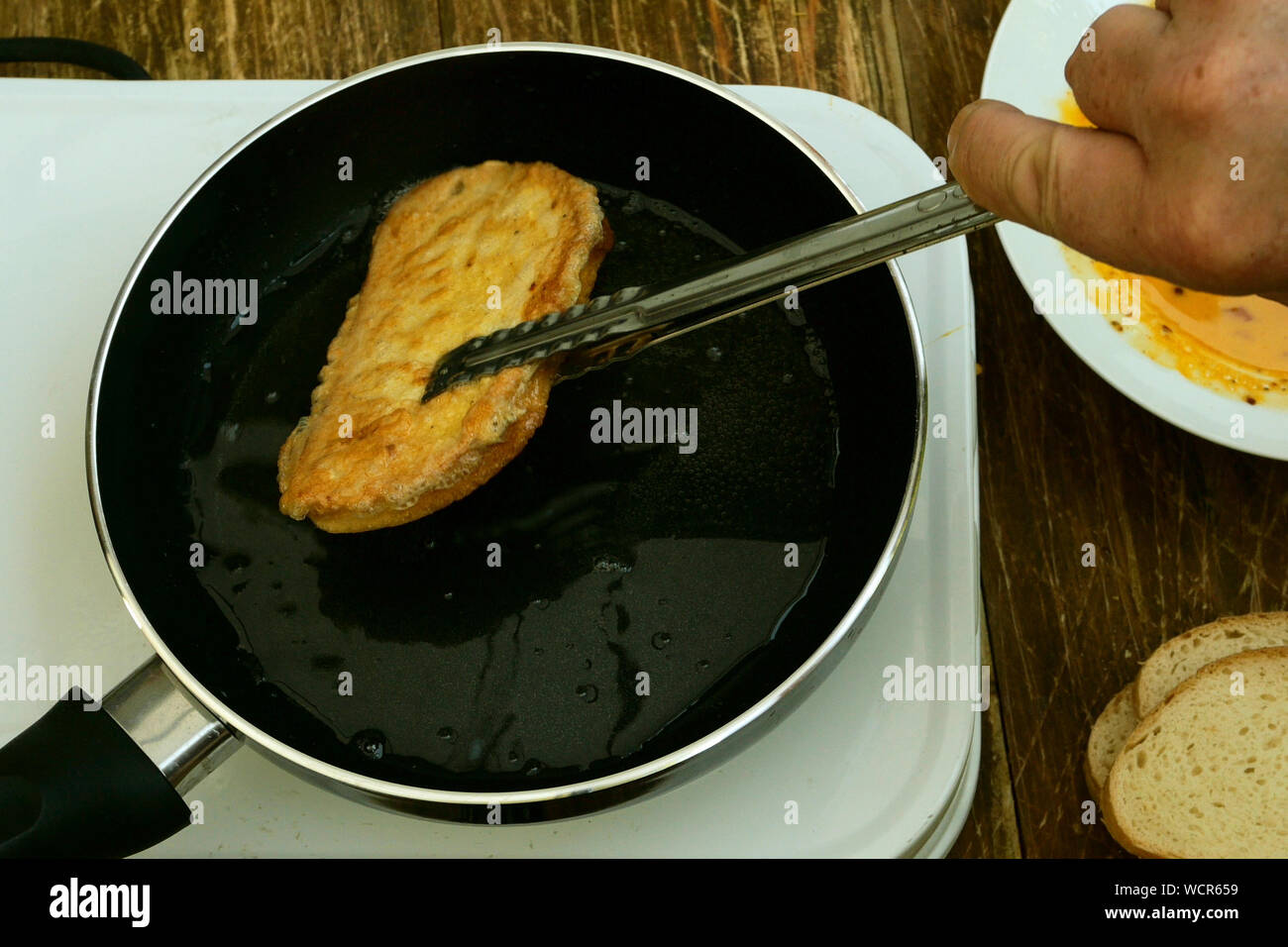 Hausgemachte Küche. Croutons oder toasts von Weißbrot, in einem geschlagen  Hühnerei getränkt, sind in der Pfanne zum Braten auf einem kleinen  elektrischen Herd gebraten. Clo Stockfotografie - Alamy