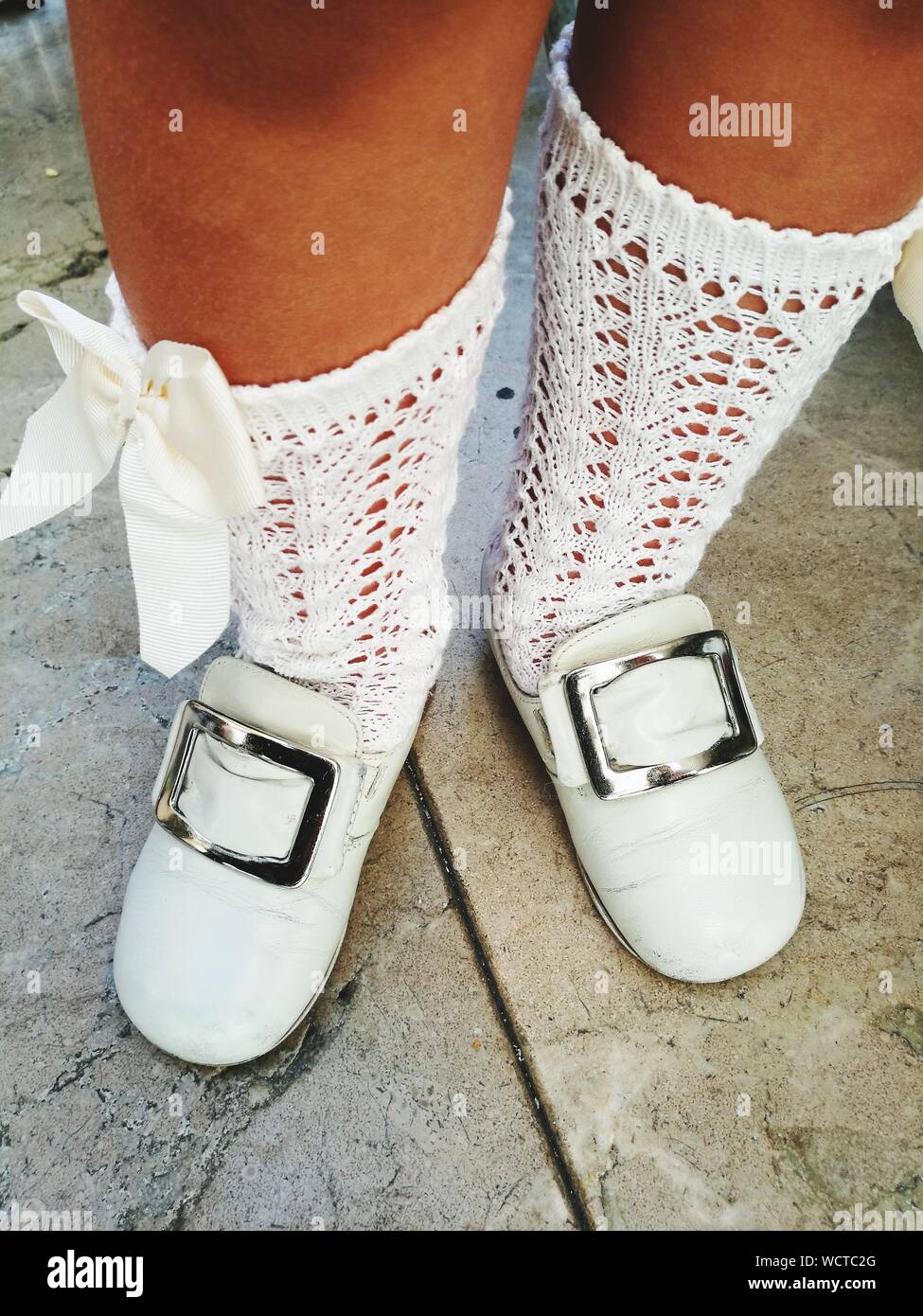 Low-Feld der Mädchen tragen weiße Schuhe mit Socken beim Stehen auf Fußweg  Stockfotografie - Alamy