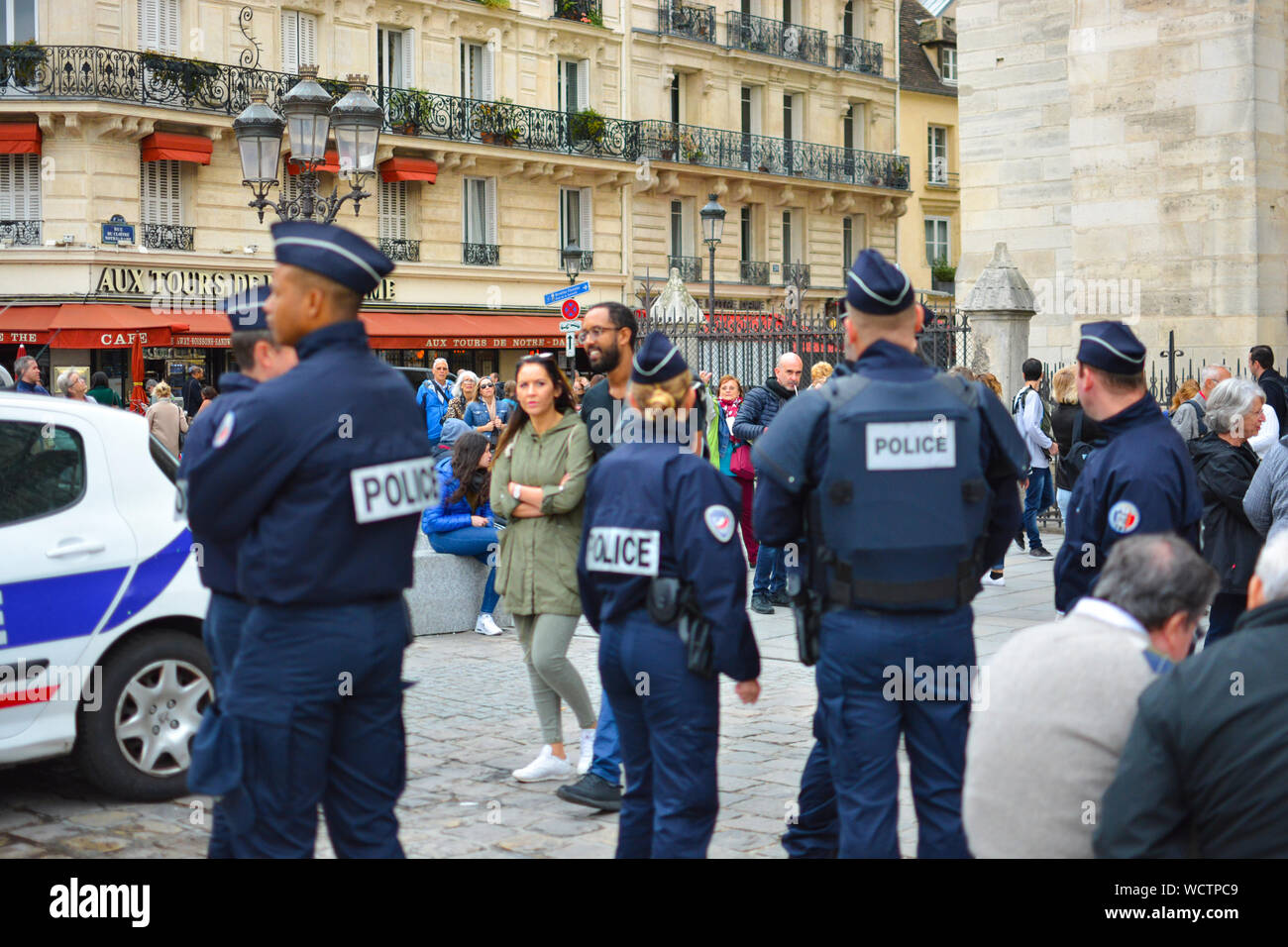 Touristen und Einheimische sind auf der französischen Polizei in Place de Notre Dame wie Sie stehen außerhalb der Kathedrale Notre Dame gerichtet Stockfoto