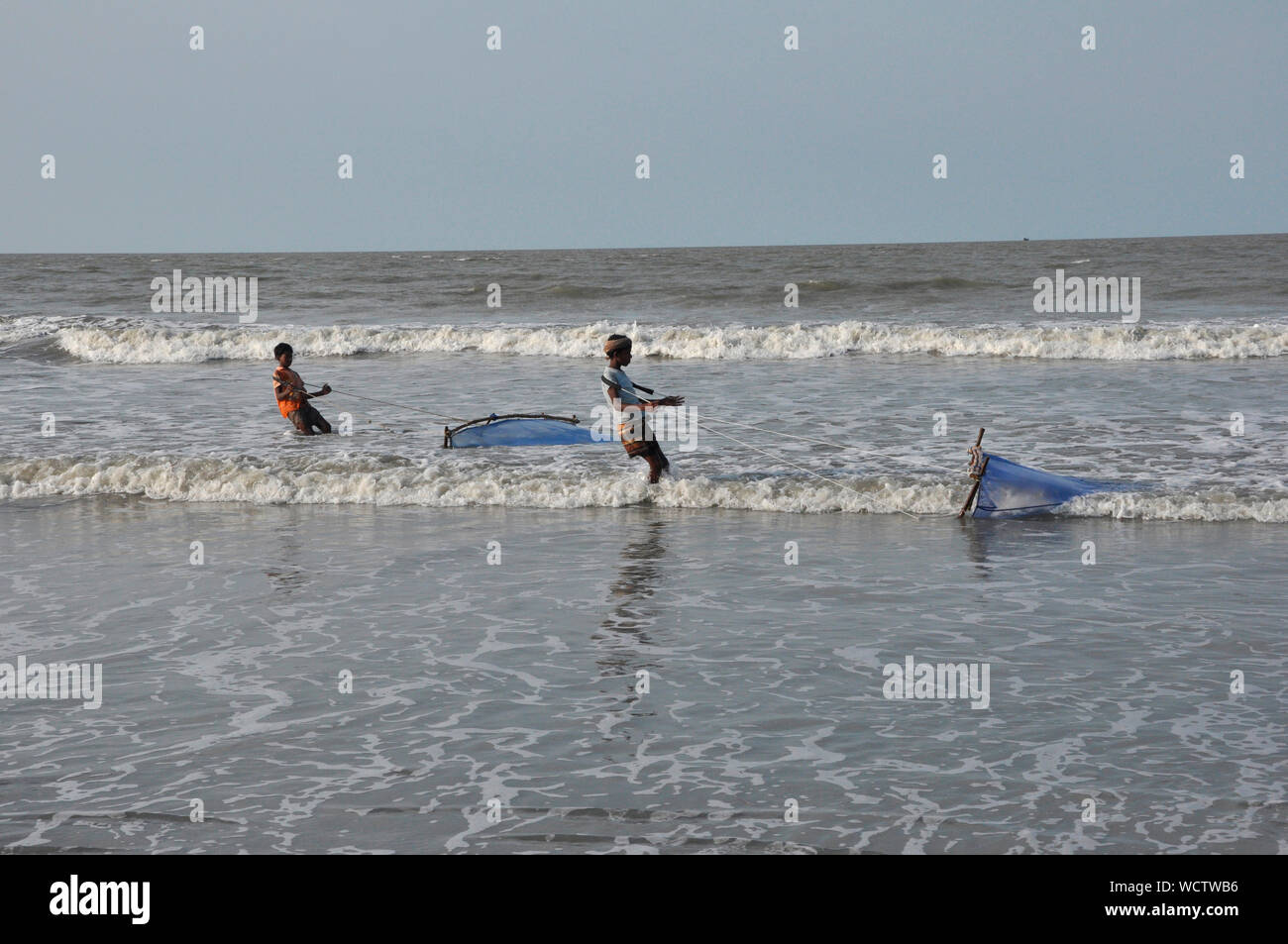 Junge Männer fangen Garnelen mit net von der Bucht von Bengalen, in Kuakata, Patuakhali, Bangladesch. 27. April 2010. Ein beliebtes Touristenziel, Kuakata ist einer der seltensten Spots der Welt, dass die volle Sicht auf den Sonnenaufgang und Sonnenuntergang über der Bucht von Bengalen bietet. Stockfoto