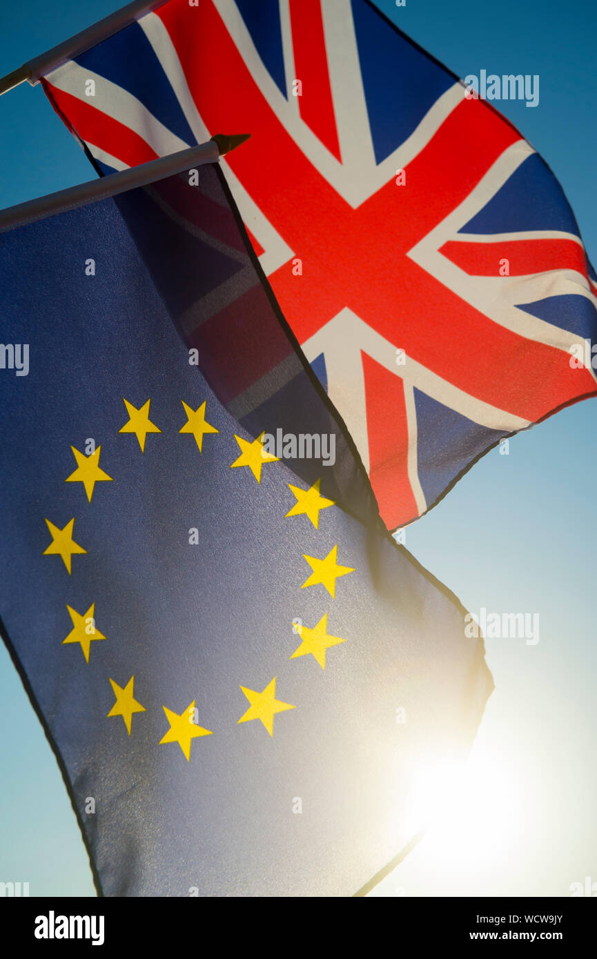 Die europäische Union und den britischen Union Jack Flagge fliegen zusammen vor strahlend blauem Himmel wie in Großbritannien unternimmt Schritte in Richtung Brexit, die EU verlassen Stockfoto