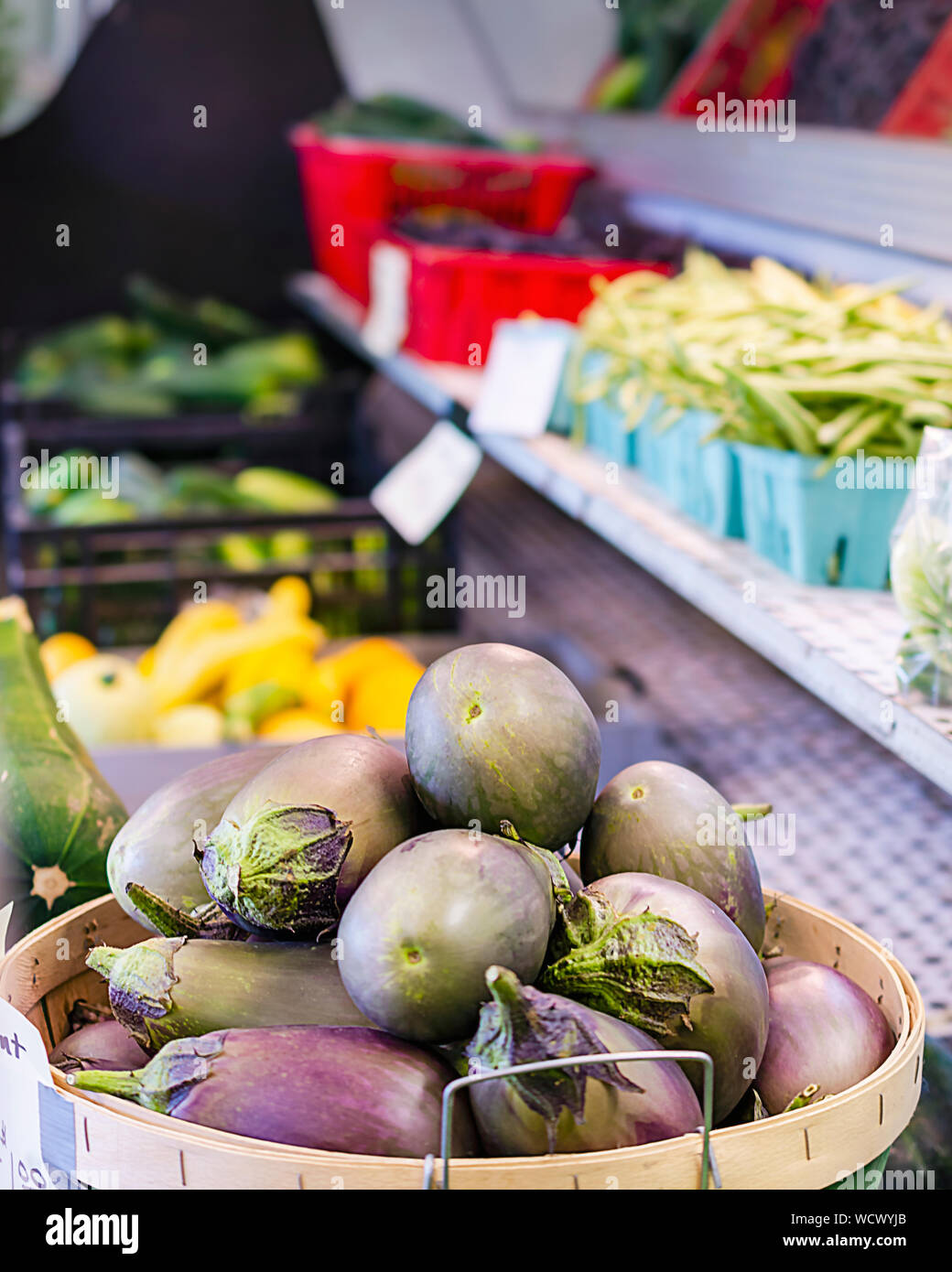 Scheffel ei Pflanze an einem strassenrand stehen Verkauf von frischen Produkten. Zusätzliche Gemüse im Hintergrund, einschließlich Bohnen, gelbe Zucchini und Gurken Stockfoto