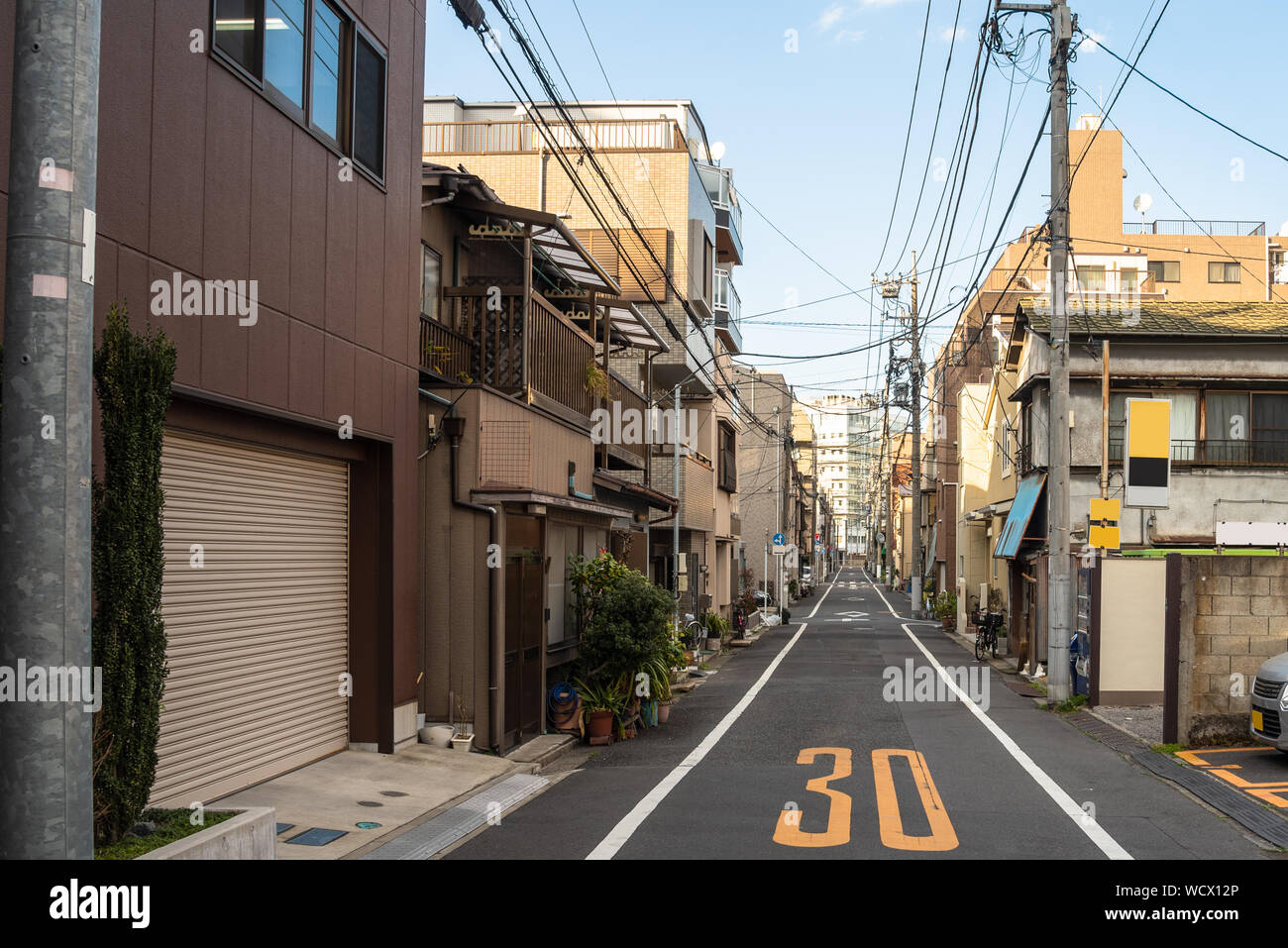 Schmale Einbahnstraße mit Wohnbauten im Zentrum von Tokyo, Japan, an einem klaren Wintertag Stockfoto