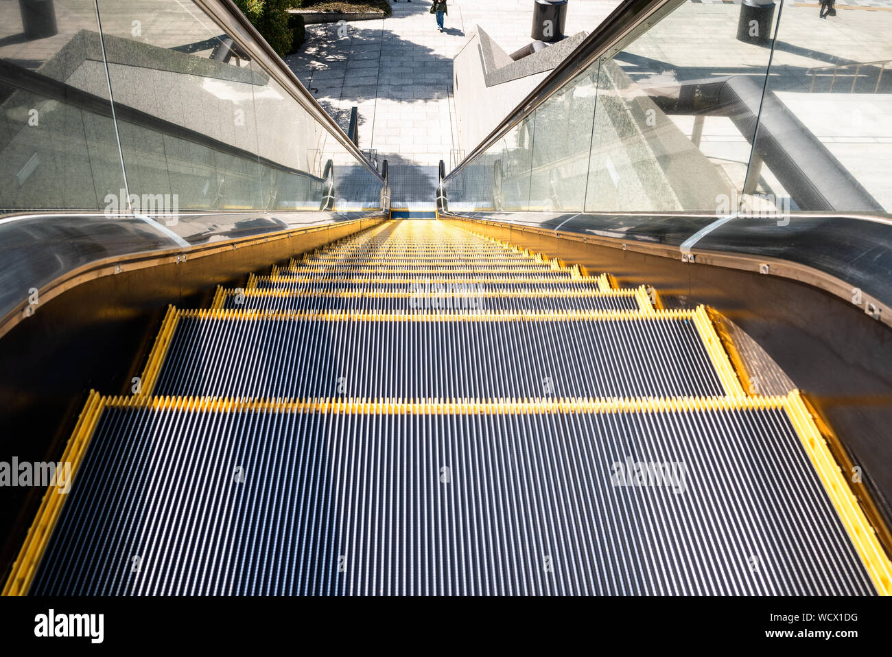 Darstellung der Schritte eines im öffentlichen Rolltreppe in einem Geschäftsviertel an einem sonnigen Tag Stockfoto