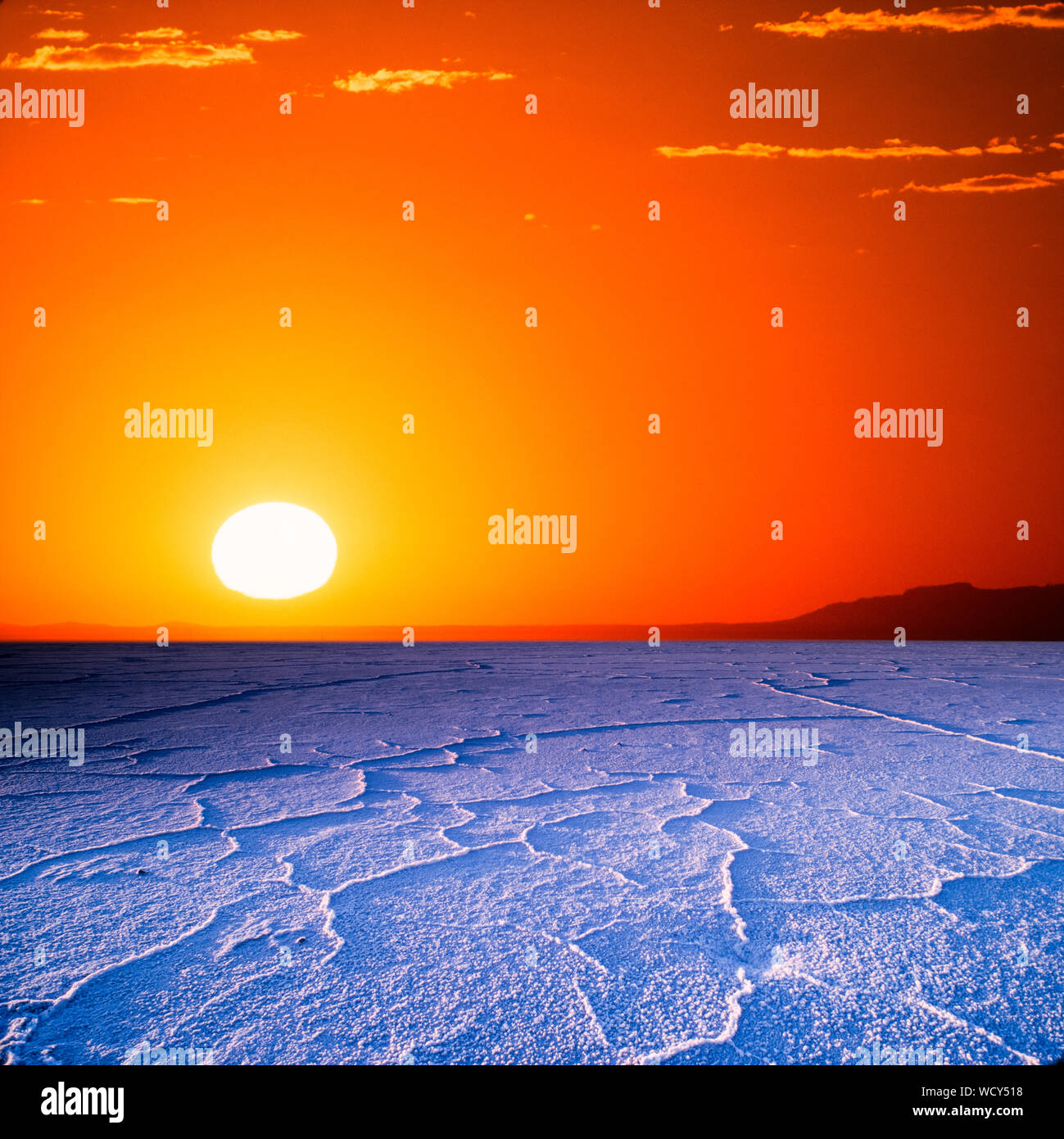Große goldene Sonnenuntergang über trockene Rissige Erde unfruchtbar. Stockfoto