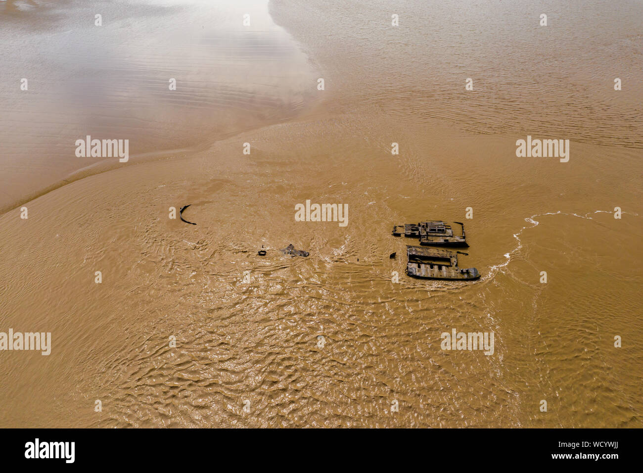 Antenne drone Ansicht aus rostendem Rümpfe der aufgegebenen Schiffe in einem braunen, schlammigen Fluss (Fluss Severn) Stockfoto