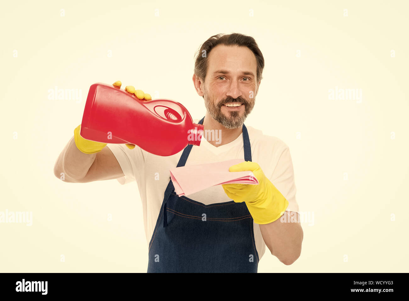 Heute ist Waschtag. Bereinigt man das Gießen Wasch Gel auf Scheibenwischer. Haushalt Arbeiter Tragen schützender Gummi Waschmaschine Handschuhe. Reifer Mann, der seine Wäsche oder Geldwäsche. Stockfoto