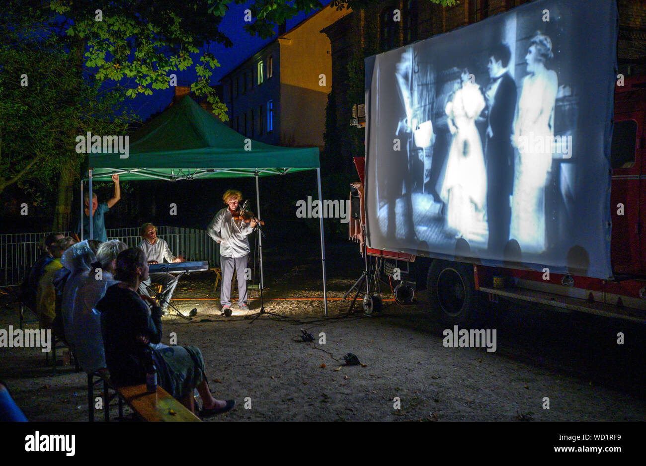 Waren, Deutschland. 28 Aug, 2019. Die Musiker Tobias Rank (Klavier) und Gunthard Stephan (Violine) spielen live verschiedenen Stillen Filme zu präsentieren. Mit ihren Reisen Kino, einer alten Feuerwehr Magirus Deutz Baujahr 1969, die beiden studierten Musiker reisen in ganz Deutschland. Alle Genres der leisen Filme gezeigt - von ihrer Entstehung im Jahre 1895 bis zum Ende der Stummfilmära um 1930. Credit: Jens Büttner/dpa-Zentralbild/dpa/Alamy leben Nachrichten Stockfoto