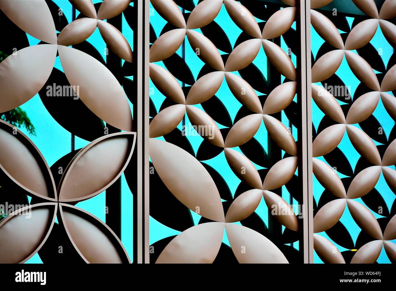 In der Nähe von Metall-cladding über blaues Glas außen mit repeat floral geometrische Muster und starke Detail als abstrakt Hintergrund Stockfoto