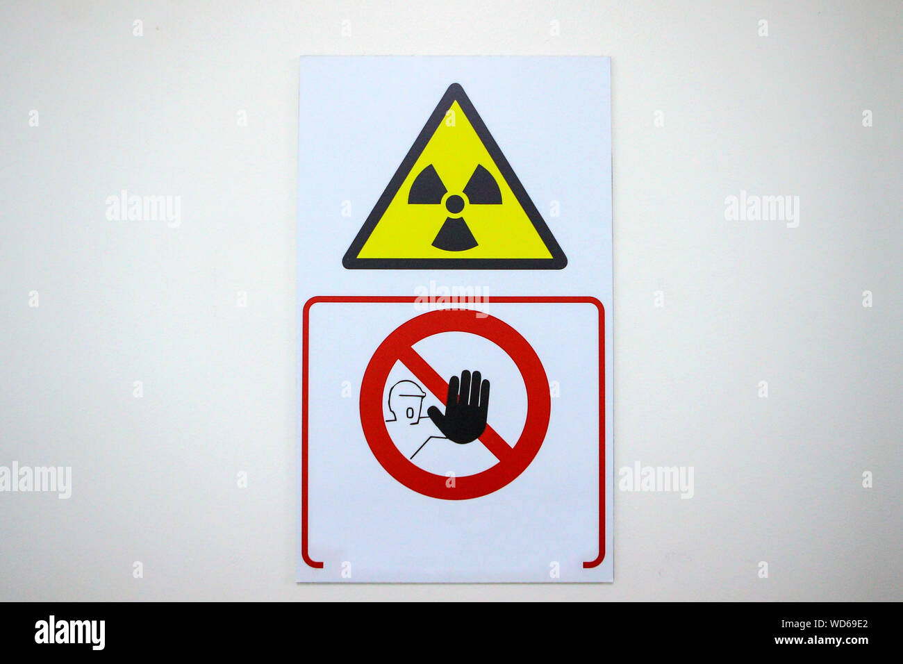 Details mit dem internationalen Strahlung Symbol (auch als Kleeblatt bekannt) zusammen mit einem fernhalten Warnung auf einer Tür Stockfoto
