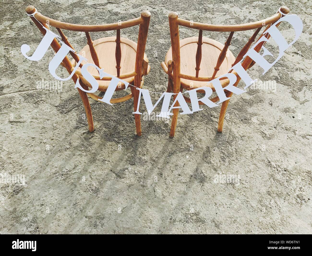 Just Married Text Hängen auf Holzstühlen am Strand Stockfoto