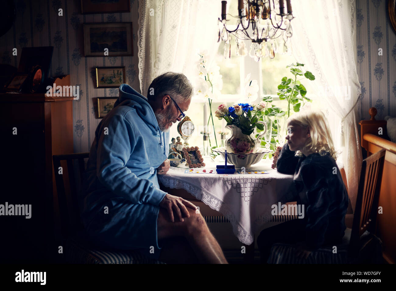 Großvater und Enkelin am Tisch mit Blumen Stockfoto