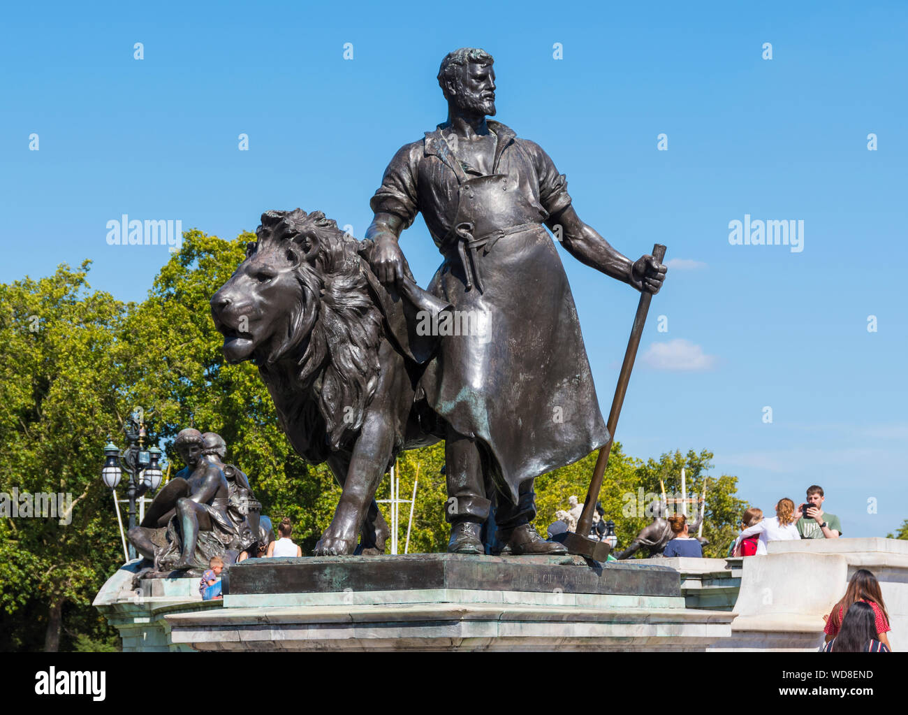 Bronzestatue, die Die Herstellung darstellt und einen Schmied & Löwen (mit der Aufschrift "The Gift of New Zealand" versehen) im Victoria Memorial in London, Großbritannien zeigt. Stockfoto