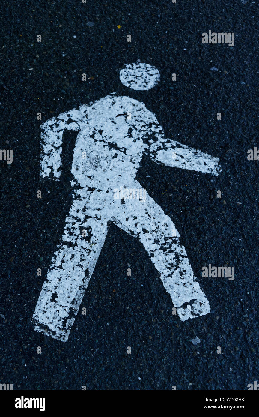 Eine weiße Schablone einer Person auf einen Fußweg, der angibt, welcher Weg zu gehen Stockfoto