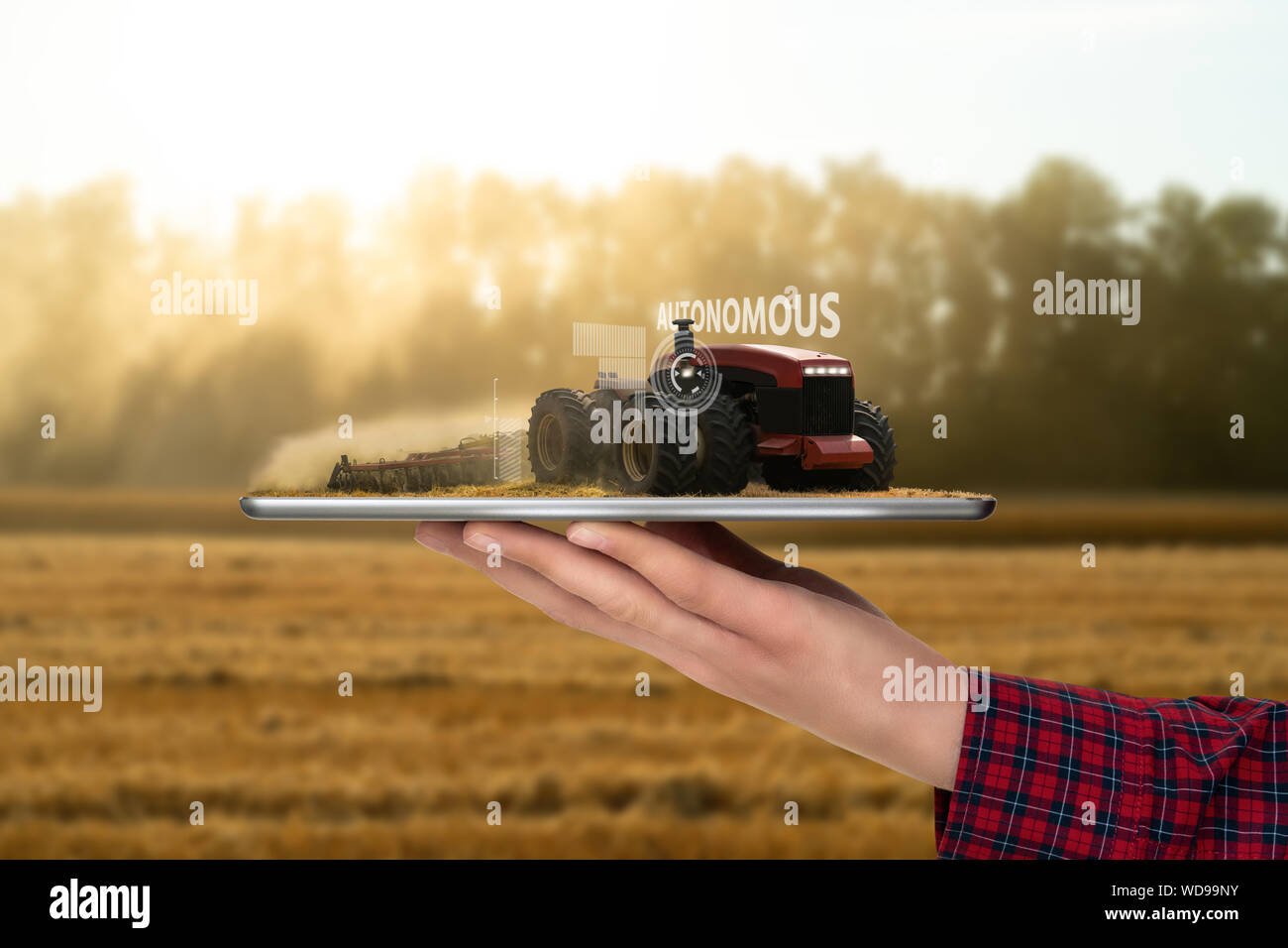 Bauer Holding eine Tablette mit autonomen Traktor. Augmented Reality und digitale Transformation in der Landwirtschaft. Smart Farming Konzept Stockfoto