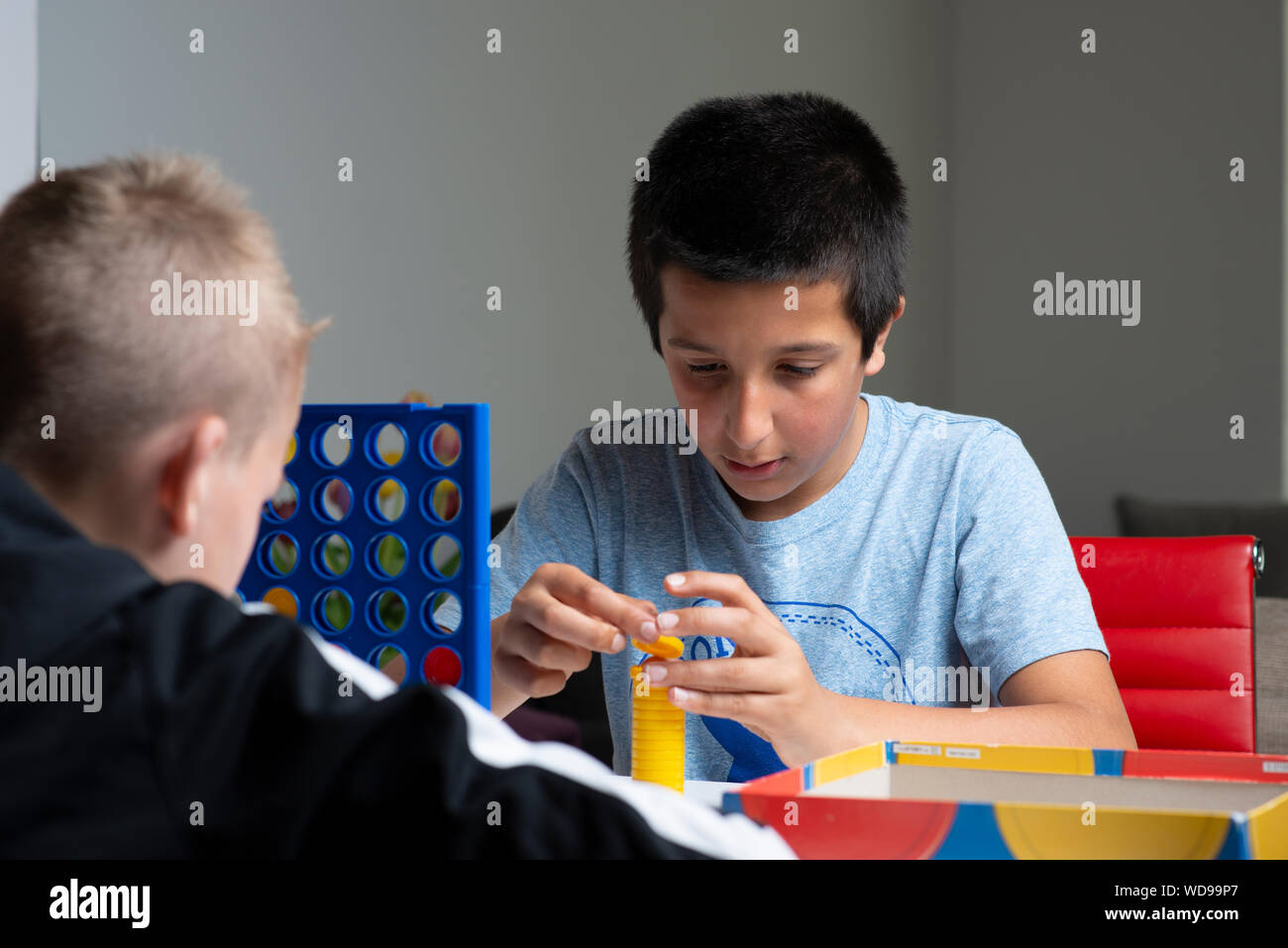 Jungen, 11-12 Jahre alt, spielen brettspiel zusammen Stockfoto