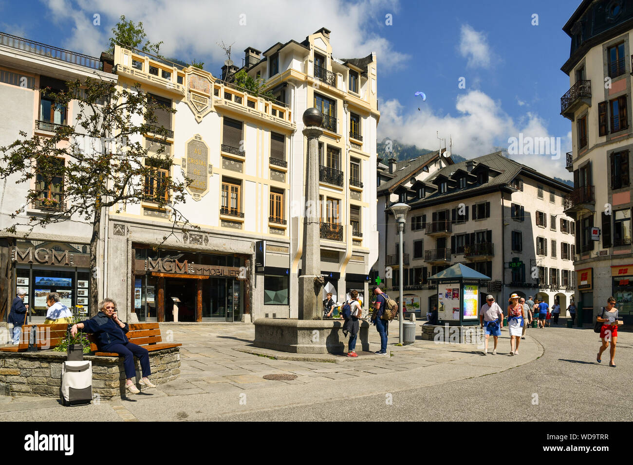 Blick auf die Straße des historischen Zentrums von Chamonix-Mont-Blanc mit Touristen zu Fuß und sitzen auf Bänken an einem sonnigen Sommertag, Haute Savoie, Frankreich Stockfoto
