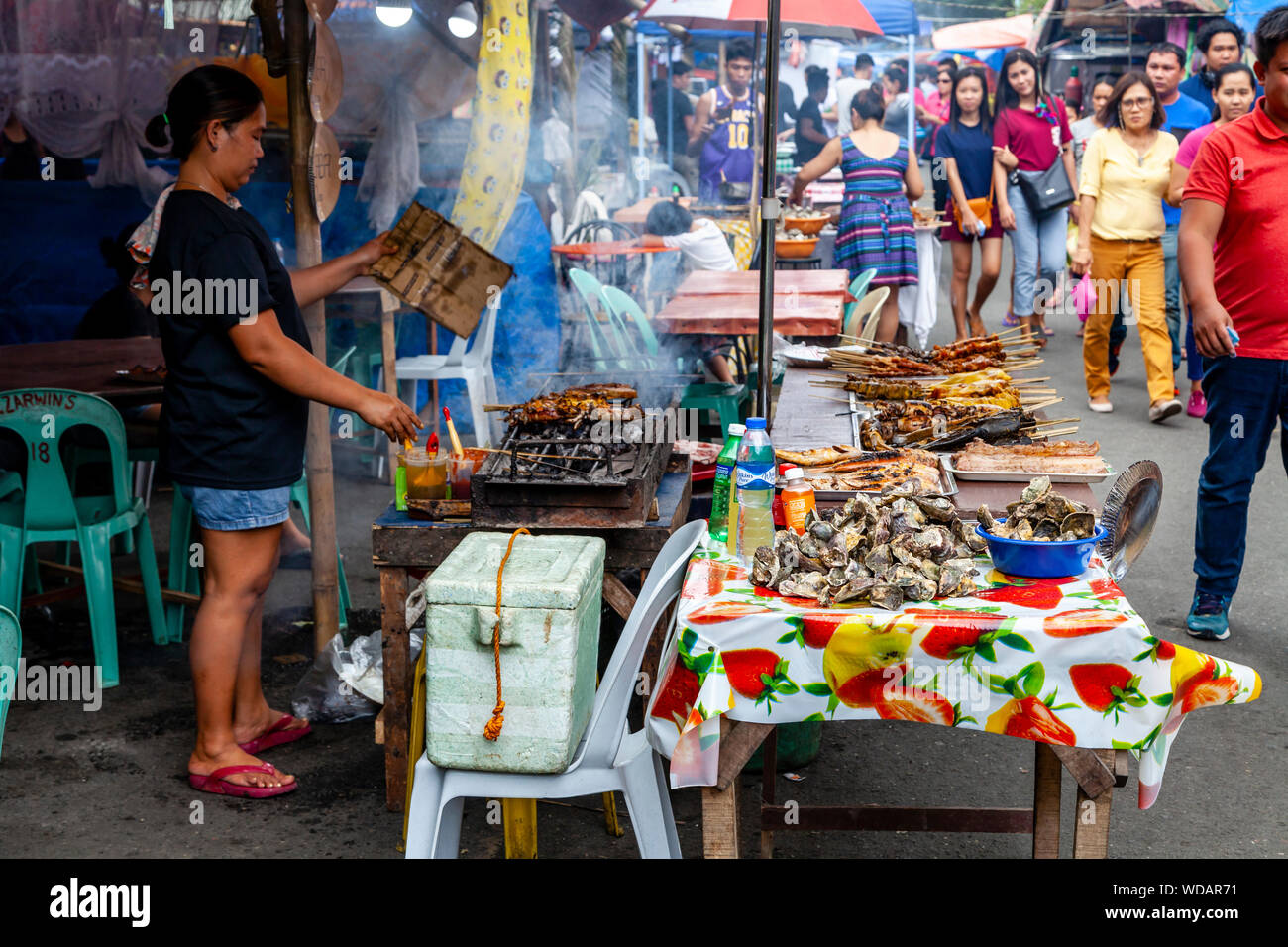 Filipino Street Food, eine philippinische Frau Kochen Fleisch auf dem Grill, Iloilo City, Panay Island, Philippinen Stockfoto