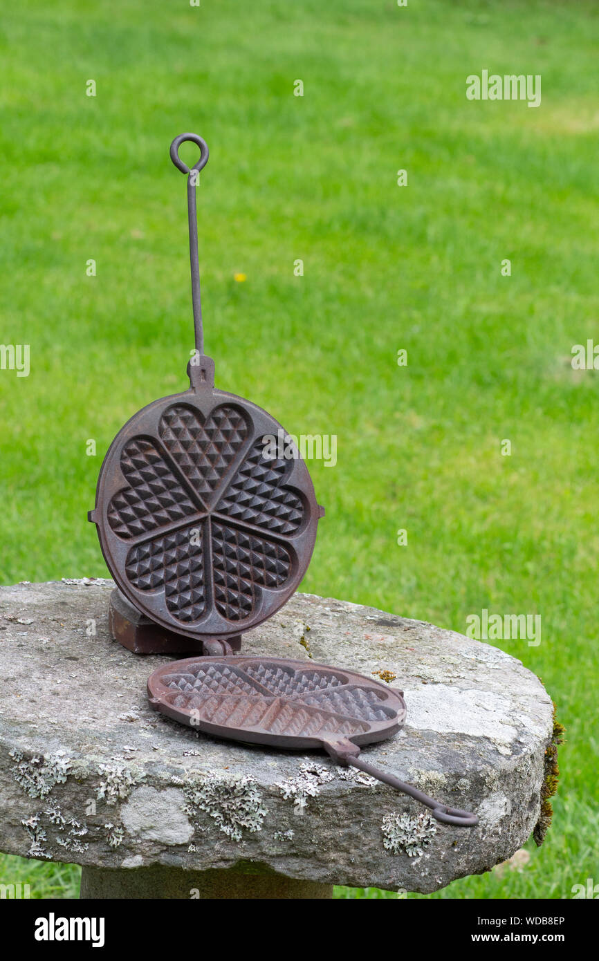 Alte Waffel - Bügeleisen auf Stein stand außerhalb Stockfoto