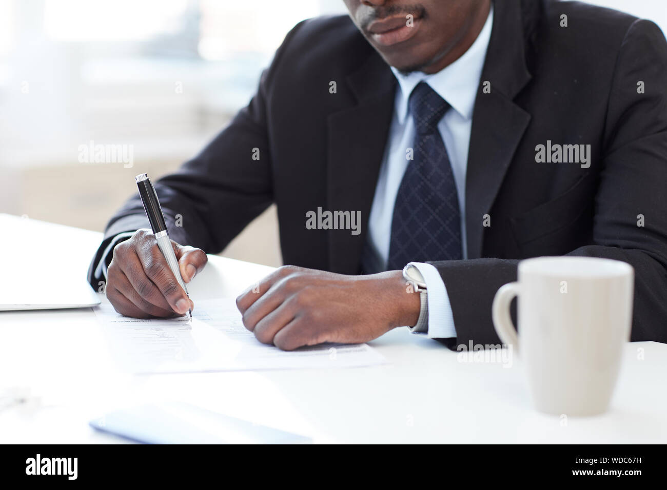 Nahaufnahme der afrikanischen Unternehmer sitzen im Büro der die Feder und die Unterzeichnung eines Business Vertrag Stockfoto